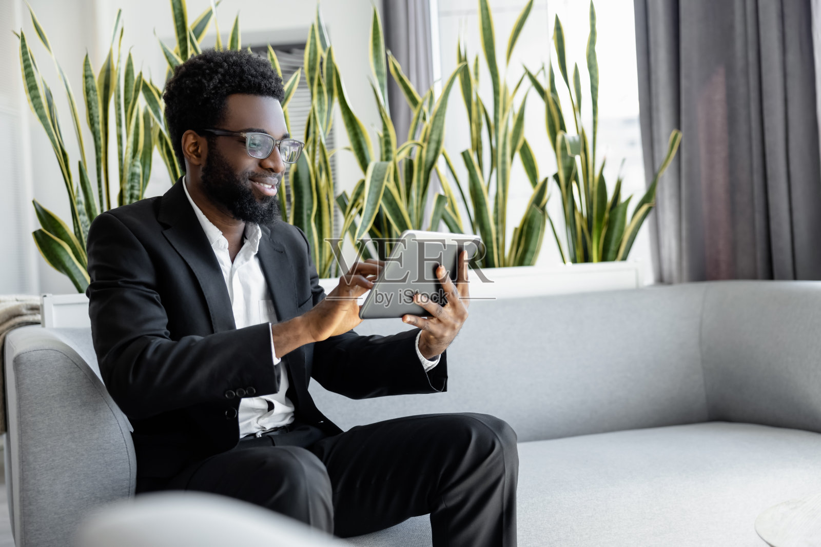 商务人士在办公室用数码平板电脑处理工作任务照片摄影图片