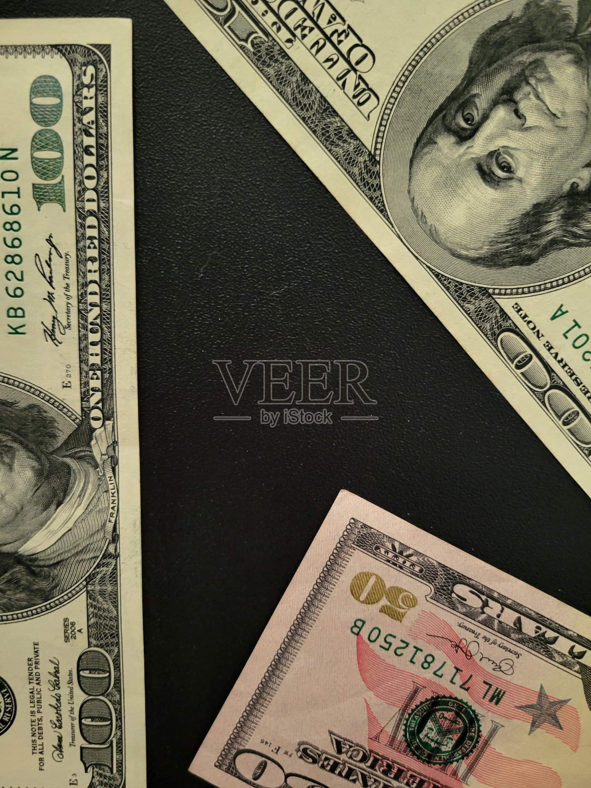 两张百元钞票和一张五十元钞票，黑底的照片摄影图片