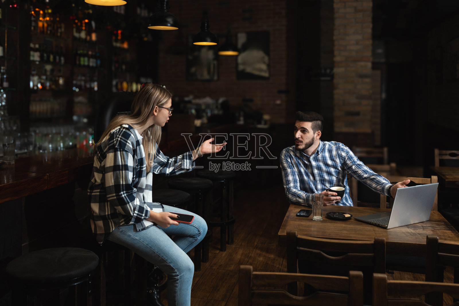 两个年轻人，丈夫和妻子，酒吧老板，在他们的自助餐厅工作，在营业时间之前打扫和计算。一男一女在咖啡店工作，从送货公司订购饮料照片摄影图片