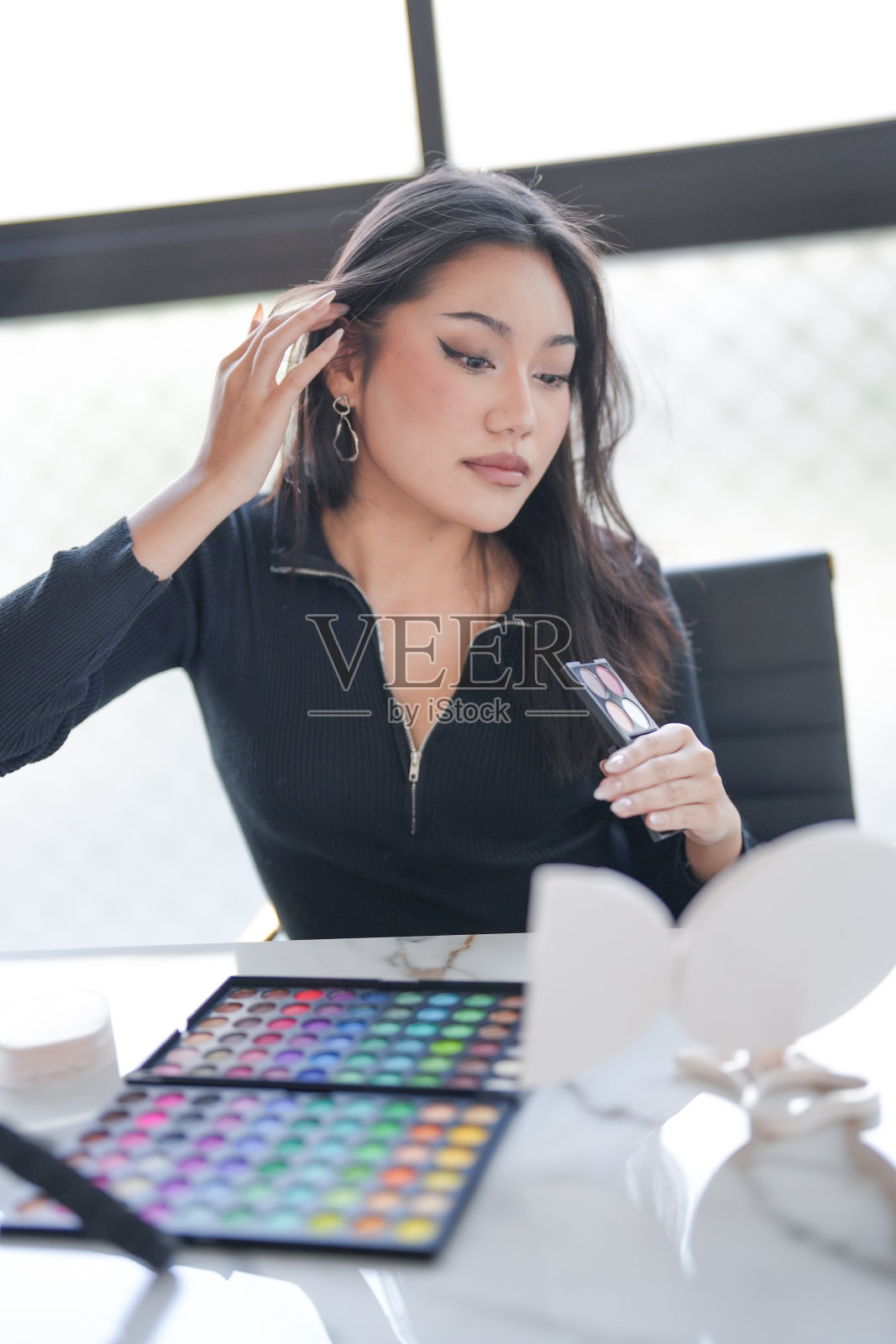 年轻的亚洲女孩化妆师职业女性博主视频博主正在展示化妆品与录制视频——美丽的亚洲女孩视频在线营销。照片摄影图片