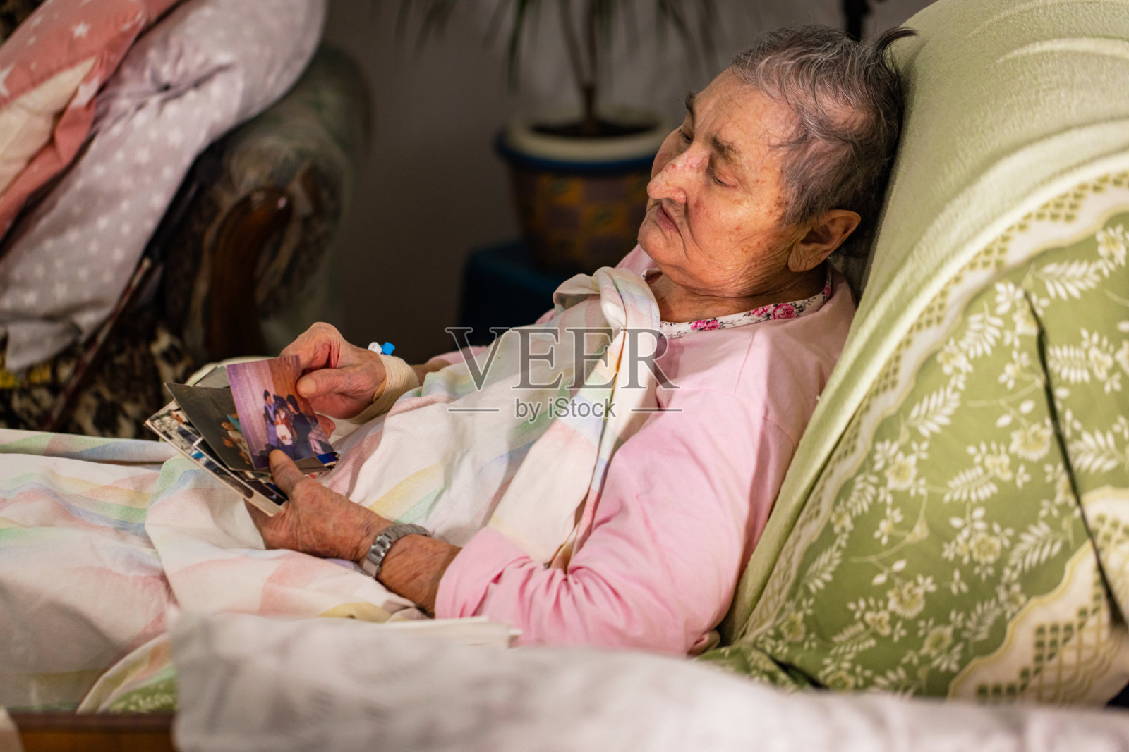 生病的老年妇女翻看家庭照片照片摄影图片