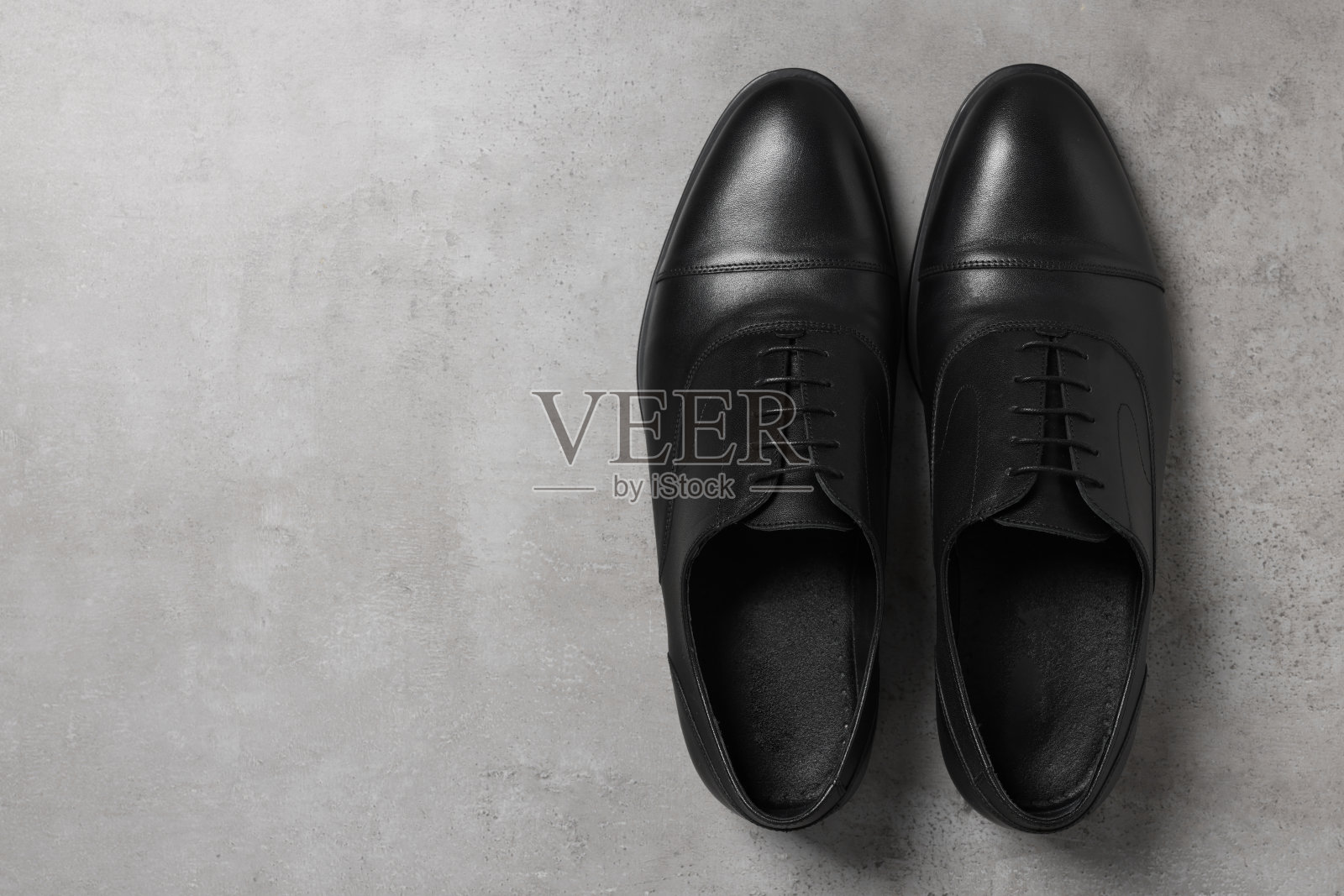 一双浅灰色表面的黑色男皮鞋，俯视图。文本空间照片摄影图片