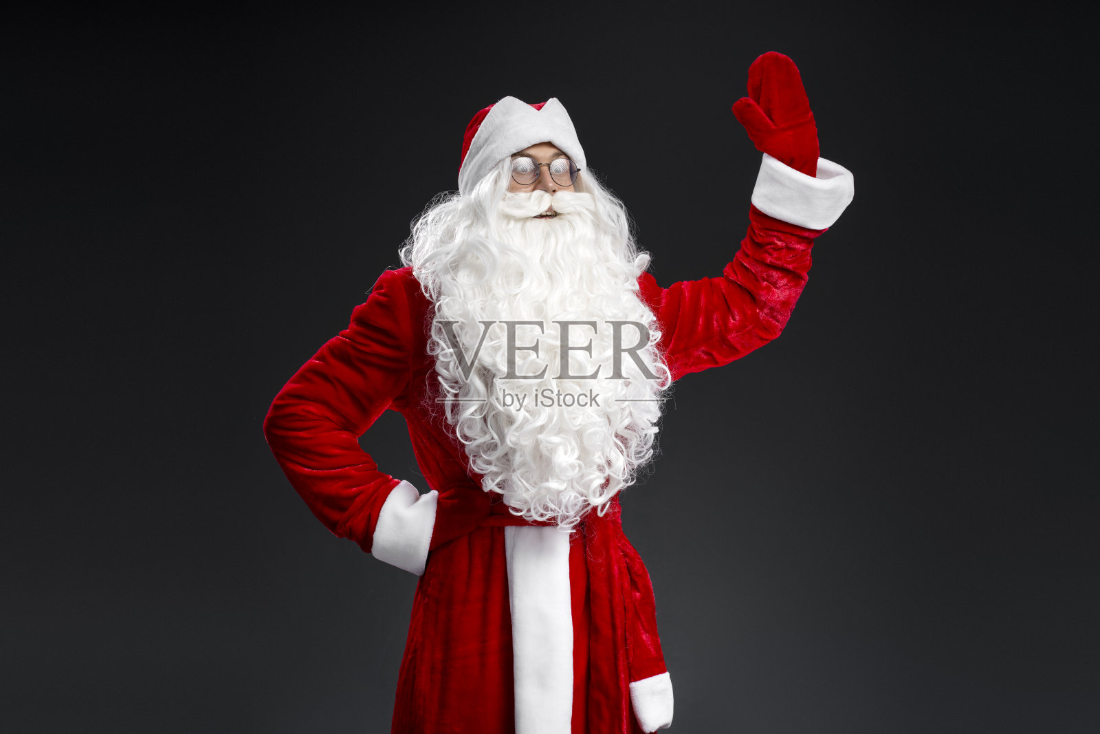 圣诞老人挥手望着远处孤立的黑色背景照片摄影图片