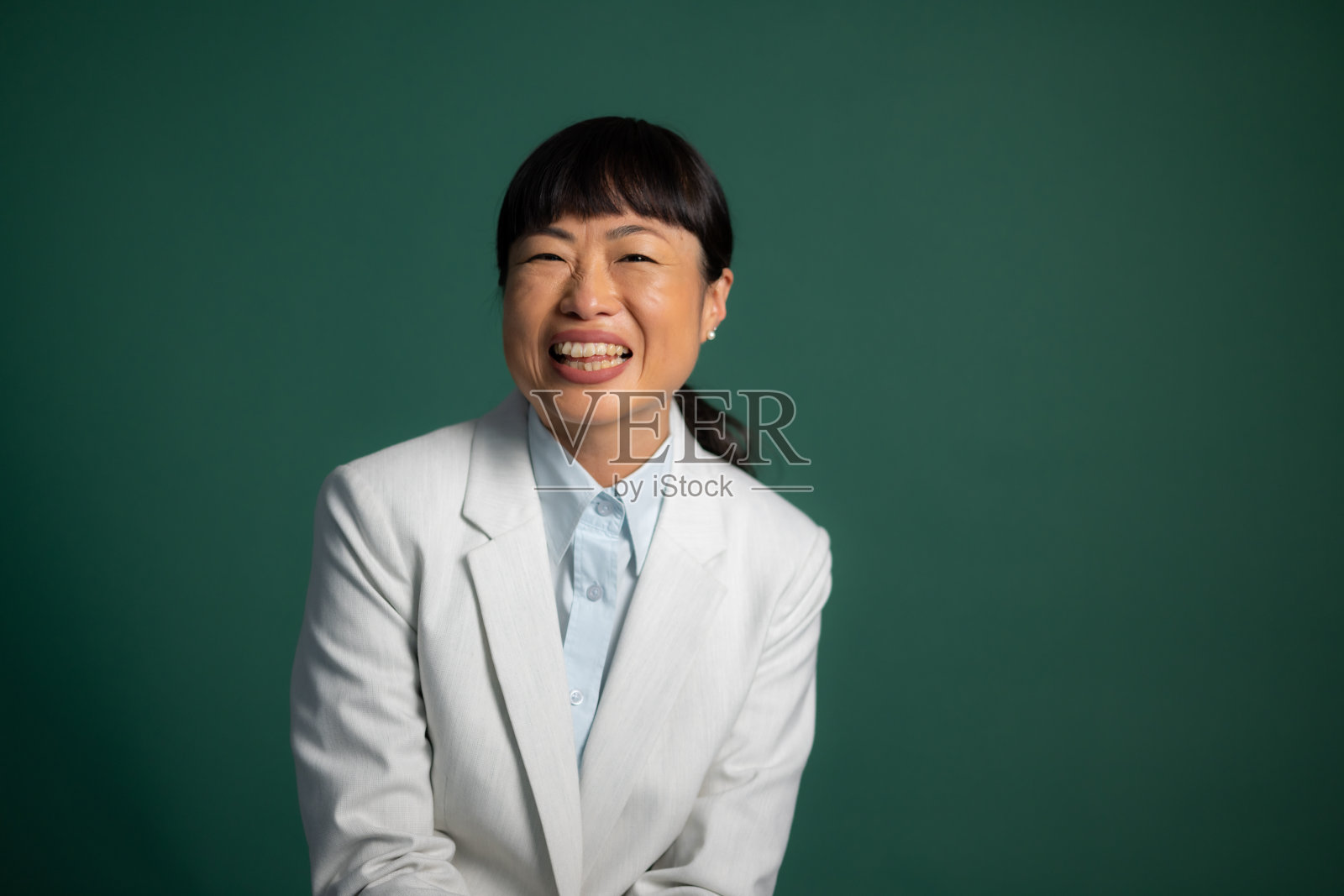 穿着白色西装微笑的亚洲女人照片摄影图片