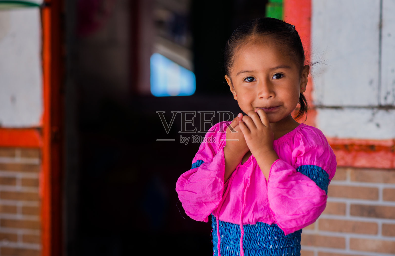一个小女孩在户外玩耍，双手捂着脸照片摄影图片