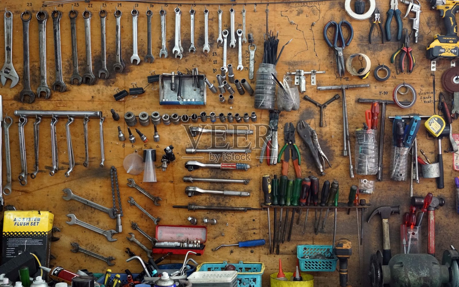 在一家汽车修理店，技工的工具挂在木墙上。照片摄影图片