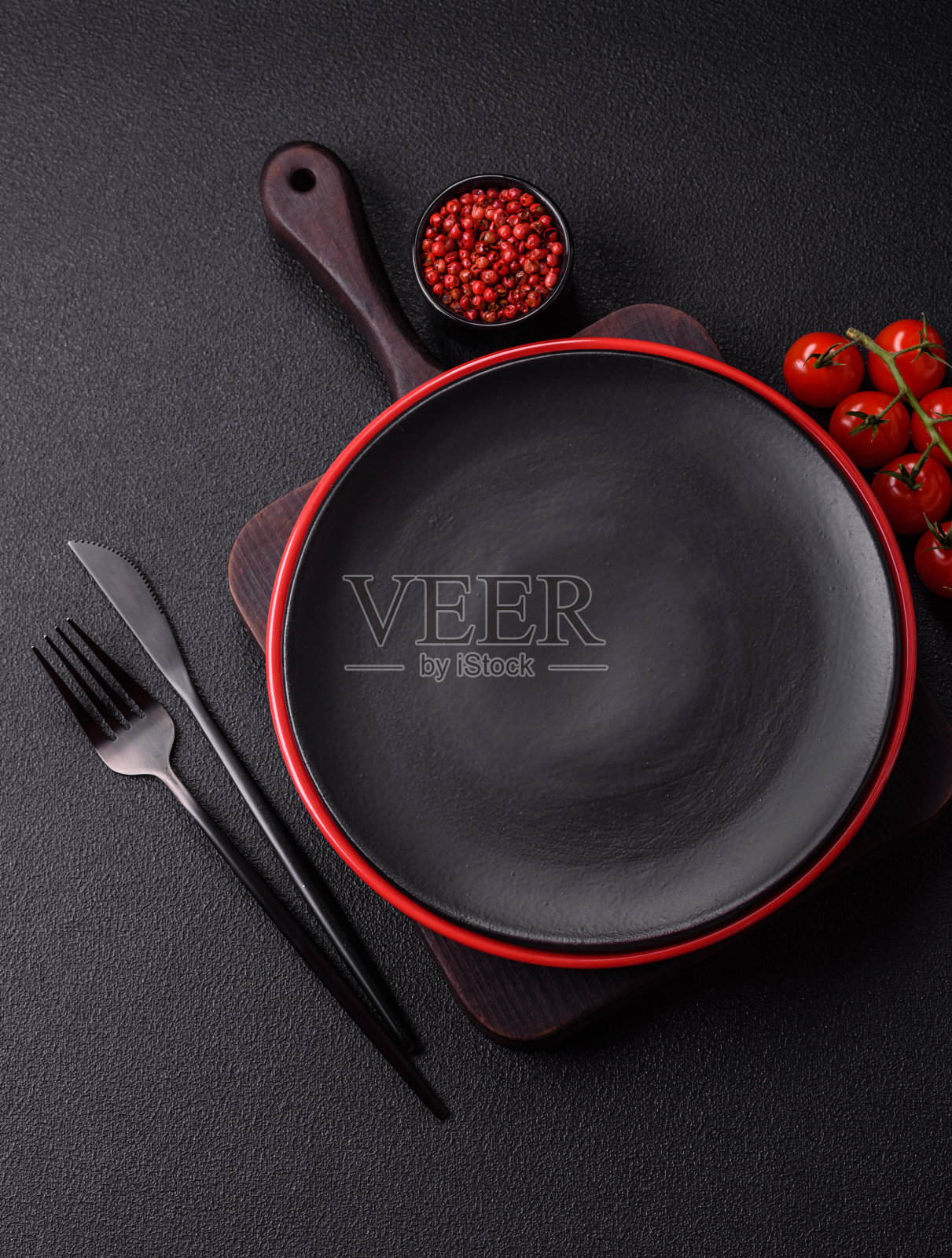 黑色纹理混凝土背景上的空陶瓷圆板照片摄影图片