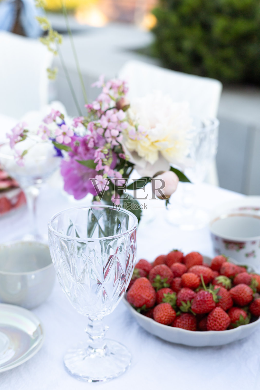 装饰的桌子，玻璃，鲜花和草莓盘照片摄影图片