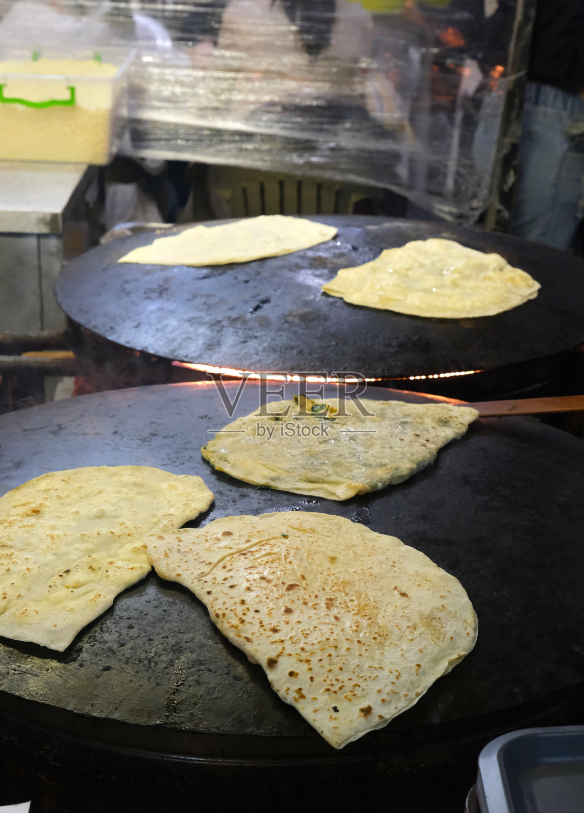 在土耳其的一个市场，在弯曲的电炉上烹饪Gözleme。照片摄影图片