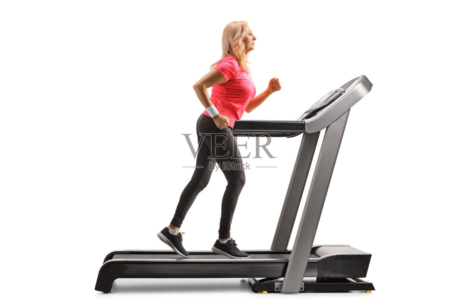 一个中年妇女在跑步机上跑步的全身侧面照照片摄影图片