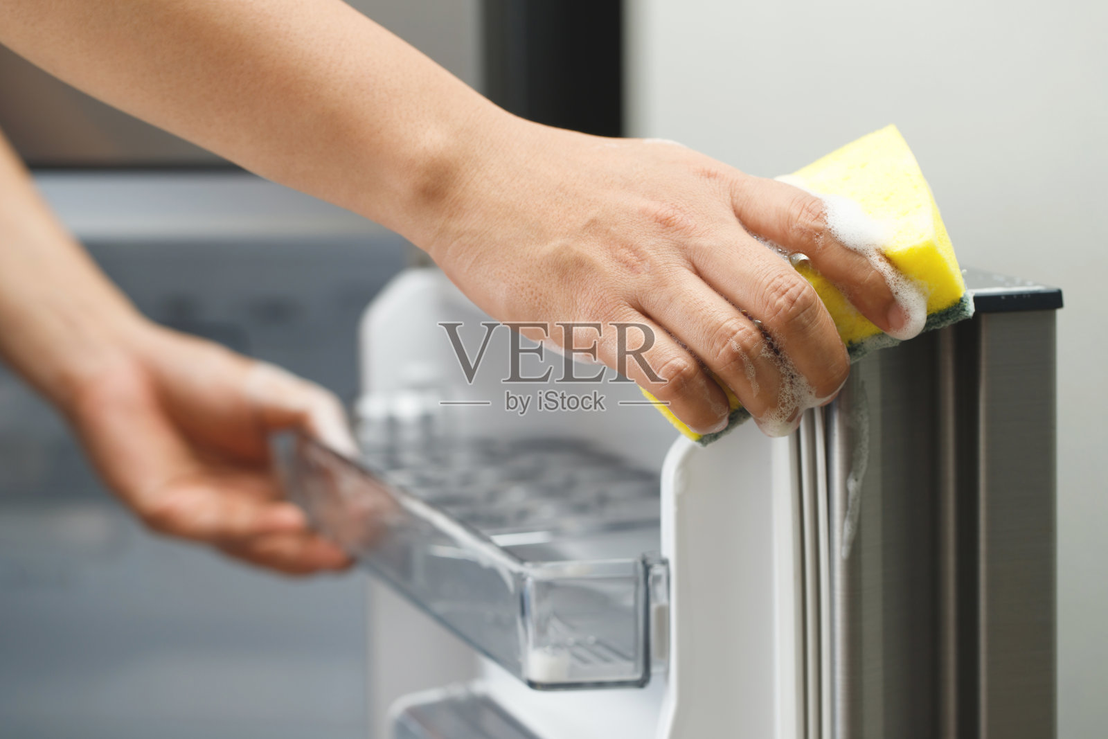 员工们用一块布清洁冰箱。照片摄影图片