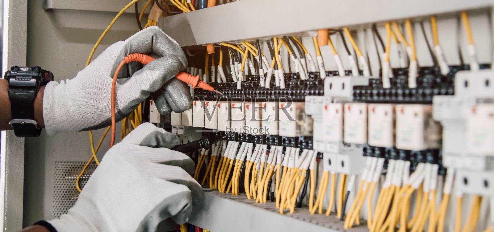 电气工程师测试继电保护系统上的电气装置和电线。照片摄影图片