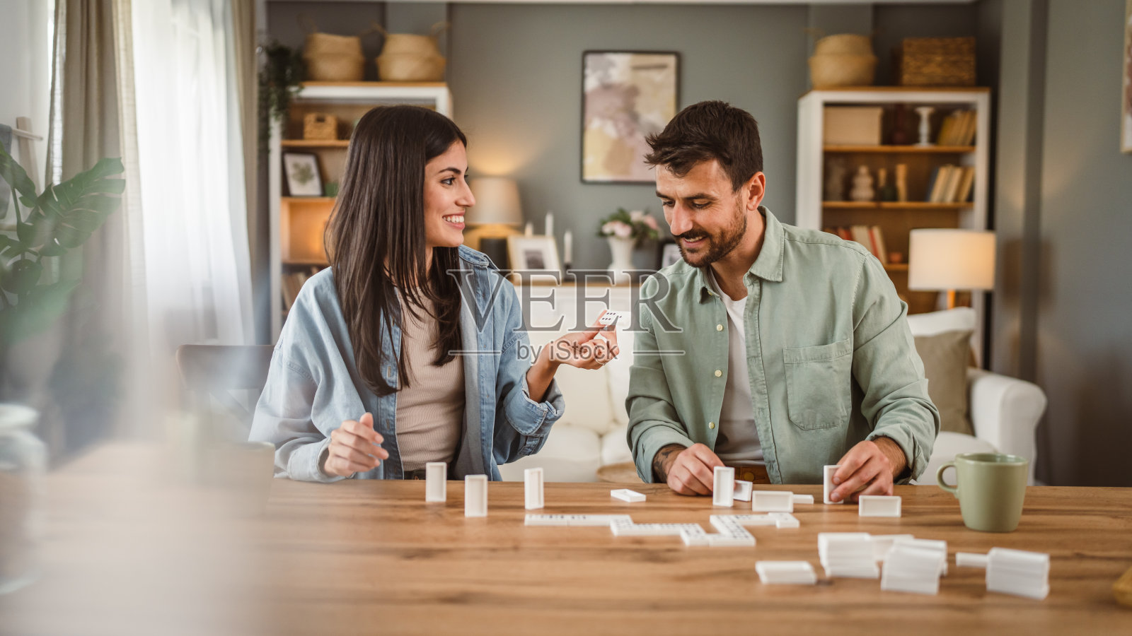 男朋友和女朋友在家里玩多米诺骨牌，一起玩得开心照片摄影图片