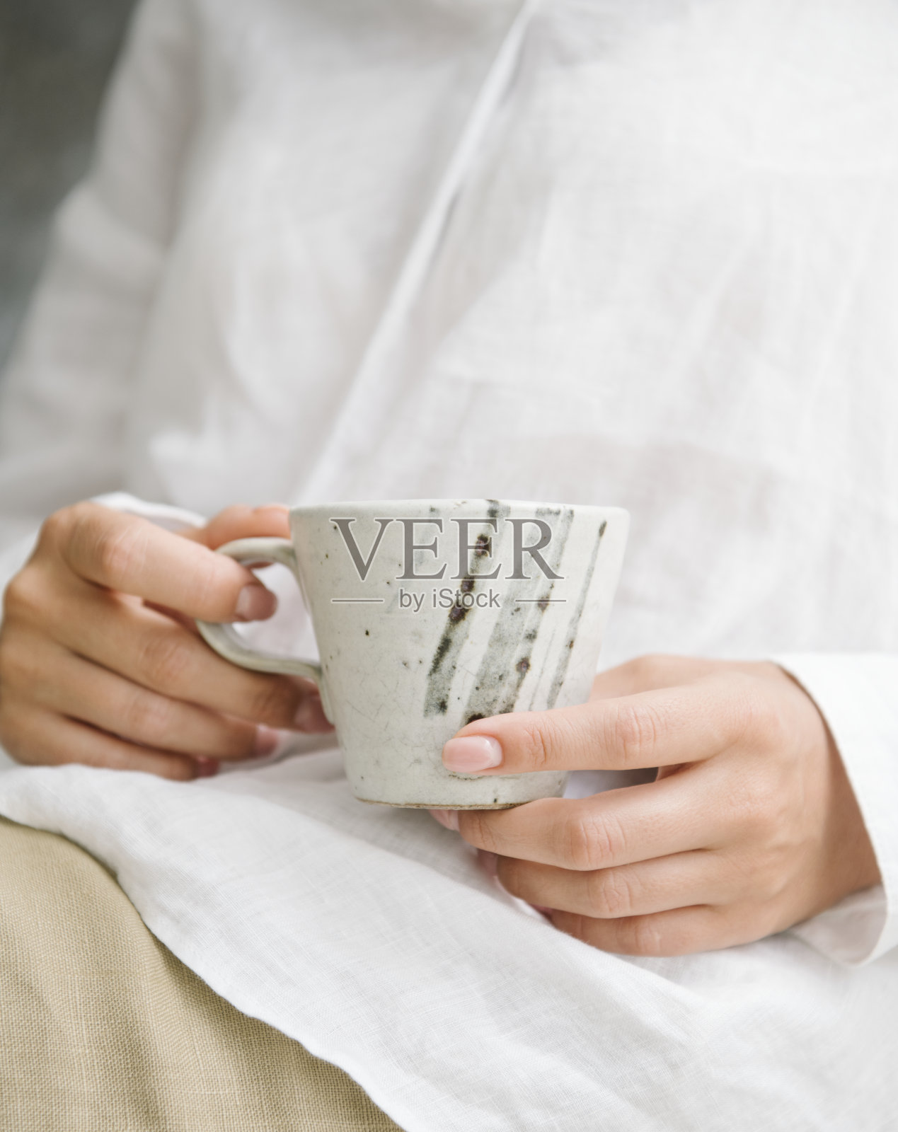 穿白衬衫的女人腿上放着一杯咖啡照片摄影图片