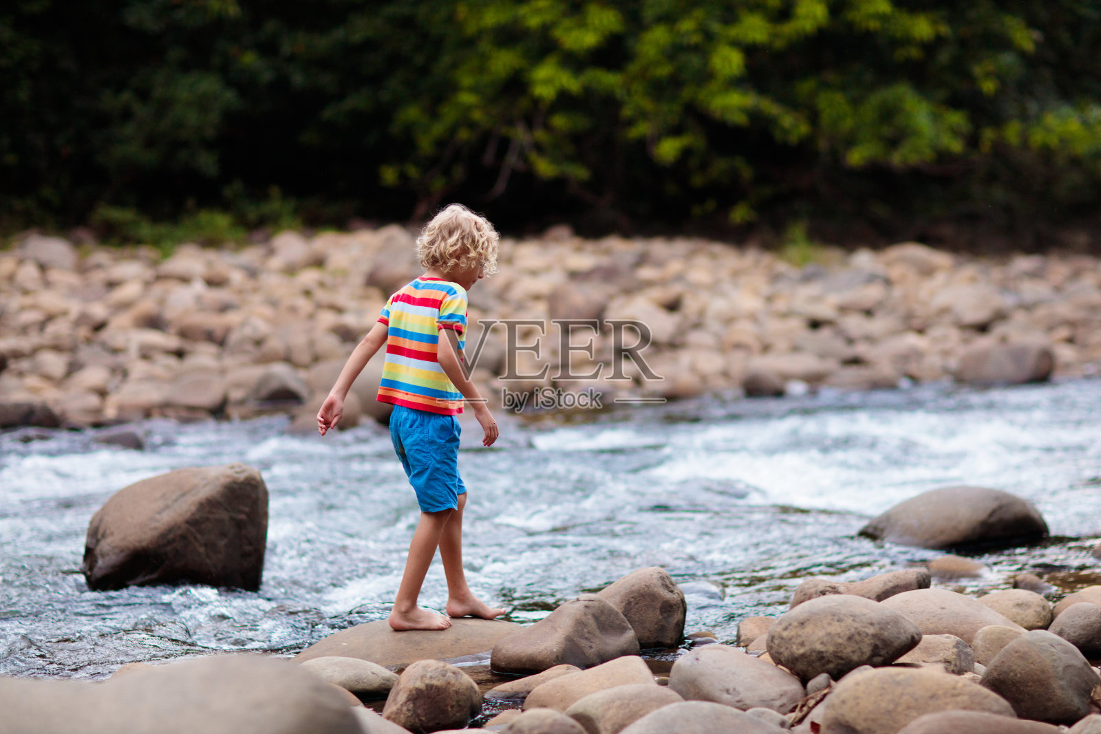 孩子在山上徒步旅行。河边的孩子们。照片摄影图片