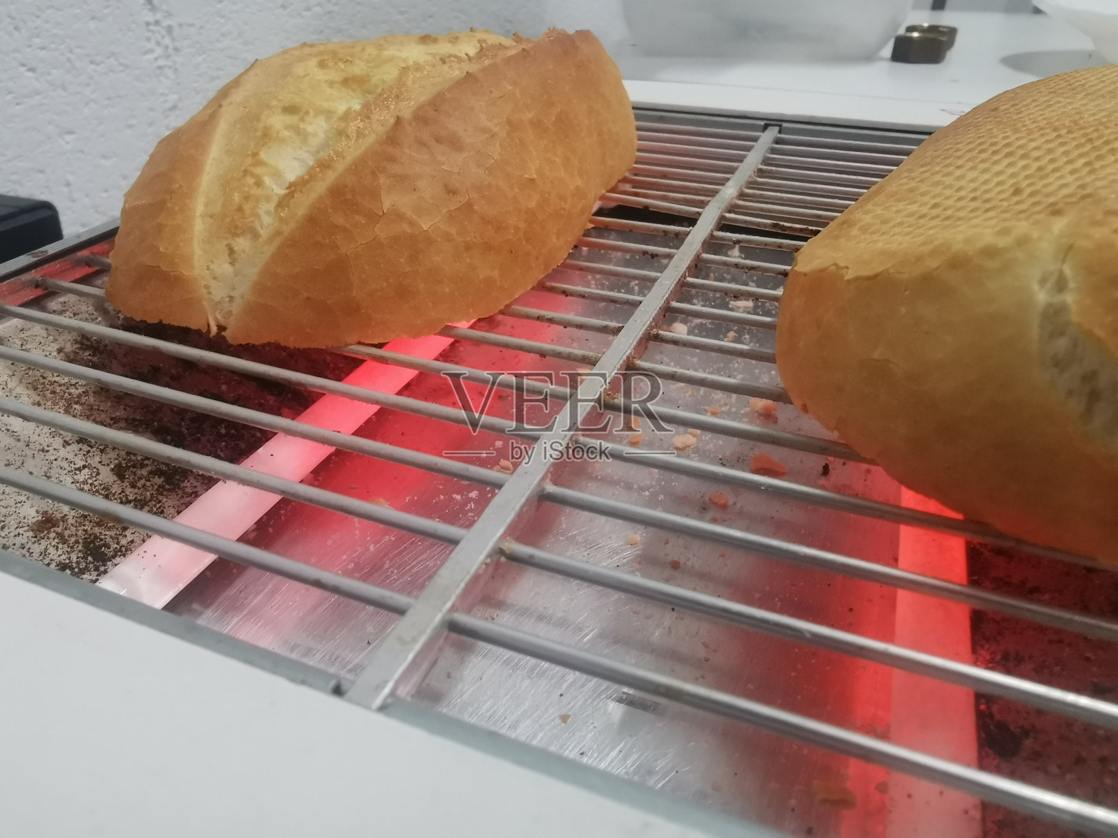 早餐面包切成两半的照片细节，放在火红的烤箱上烤照片摄影图片