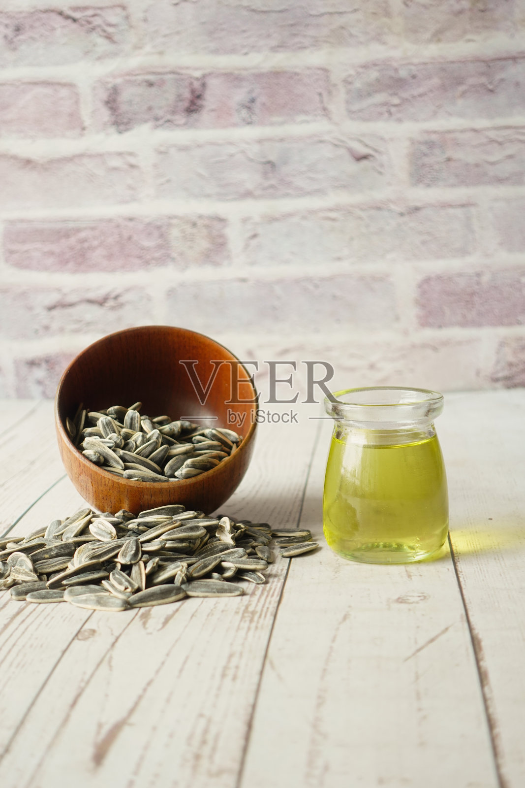葵花籽和油放在桌子上的容器里照片摄影图片