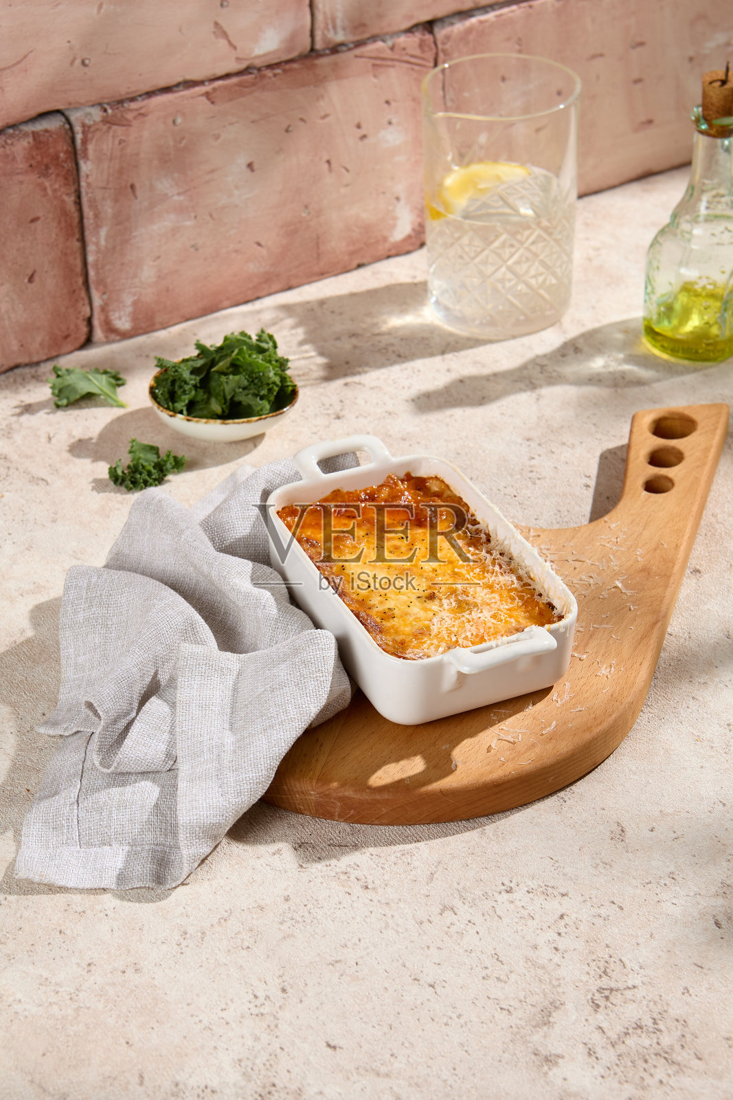 正宗的千层面在自然米色桌子上的陶瓷盘子与阳光和阴影<e:2>”静物生活方式摄影照片摄影图片