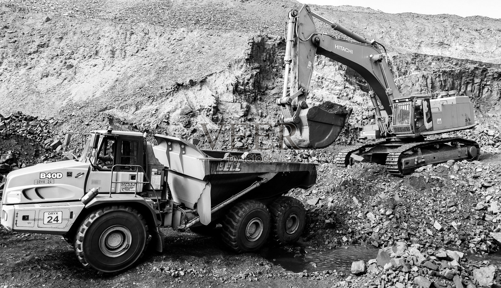 背景中有两辆卡车和一台大型挖掘机照片摄影图片