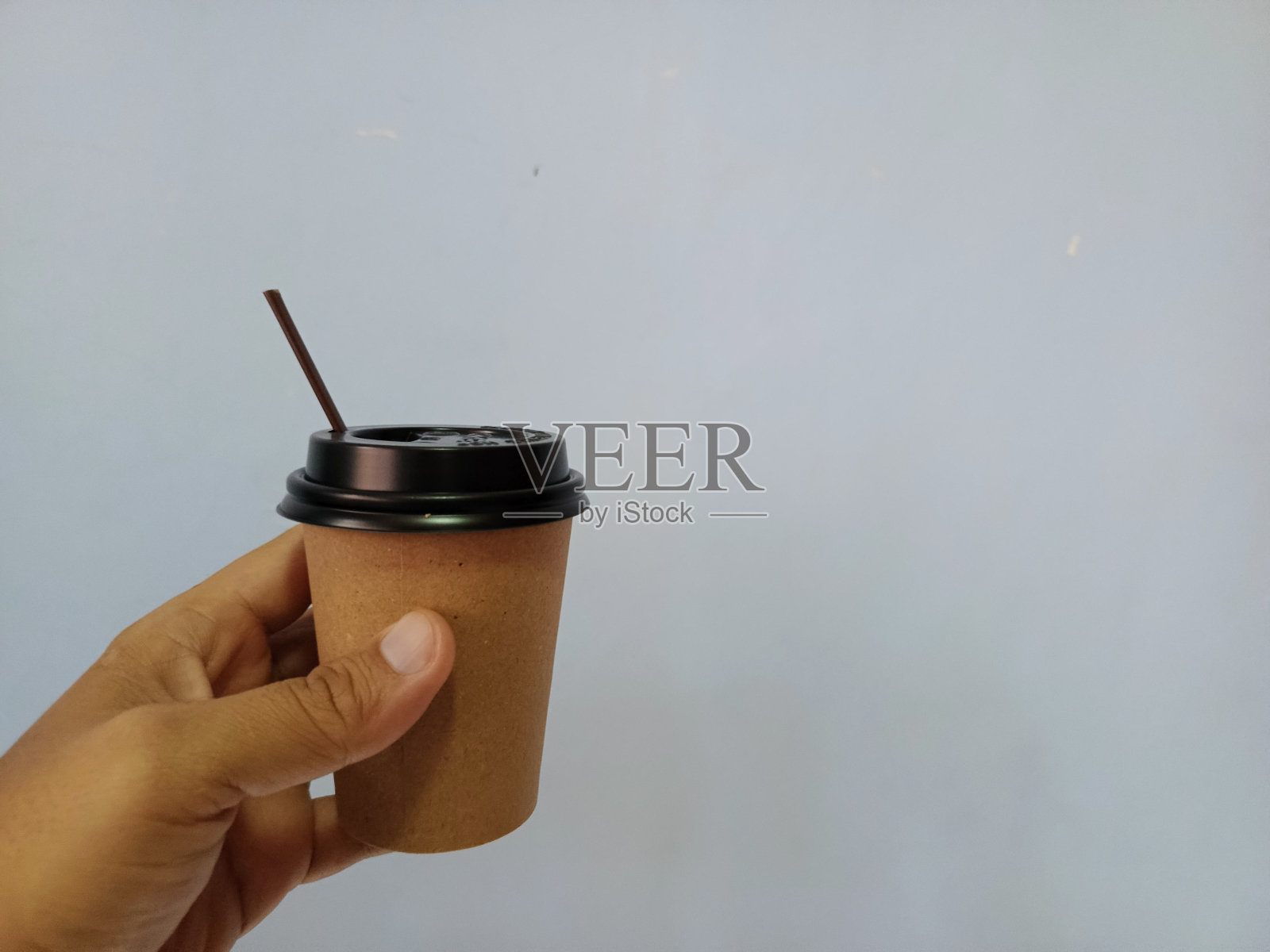 手拿着一个灰色背景的咖啡杯照片摄影图片