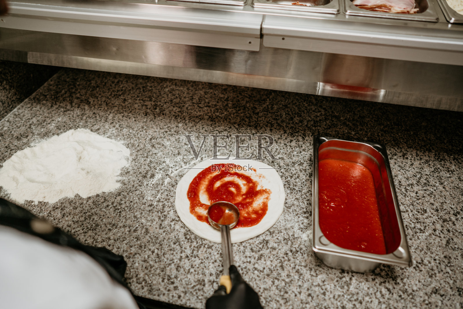 年轻英俊的披萨面包师在做披萨照片摄影图片