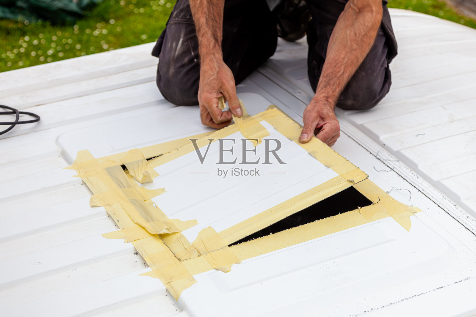 DIY露营车跳车转换。外面有个新窗户。用电动拼图机切割。安装顶窗前的准备工作。照片摄影图片