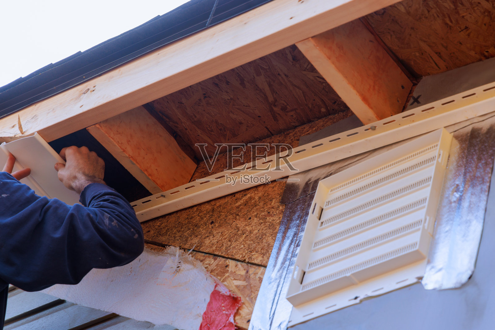 在住宅的屋面下沿屋顶线安装的乙烯基白色uPVC斜板如图所示。照片摄影图片