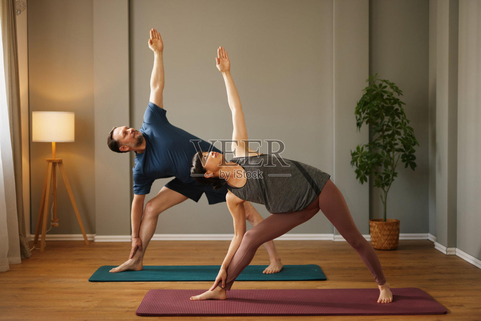 白人男子和亚洲女子在瑜伽馆一起练习瑜伽照片摄影图片