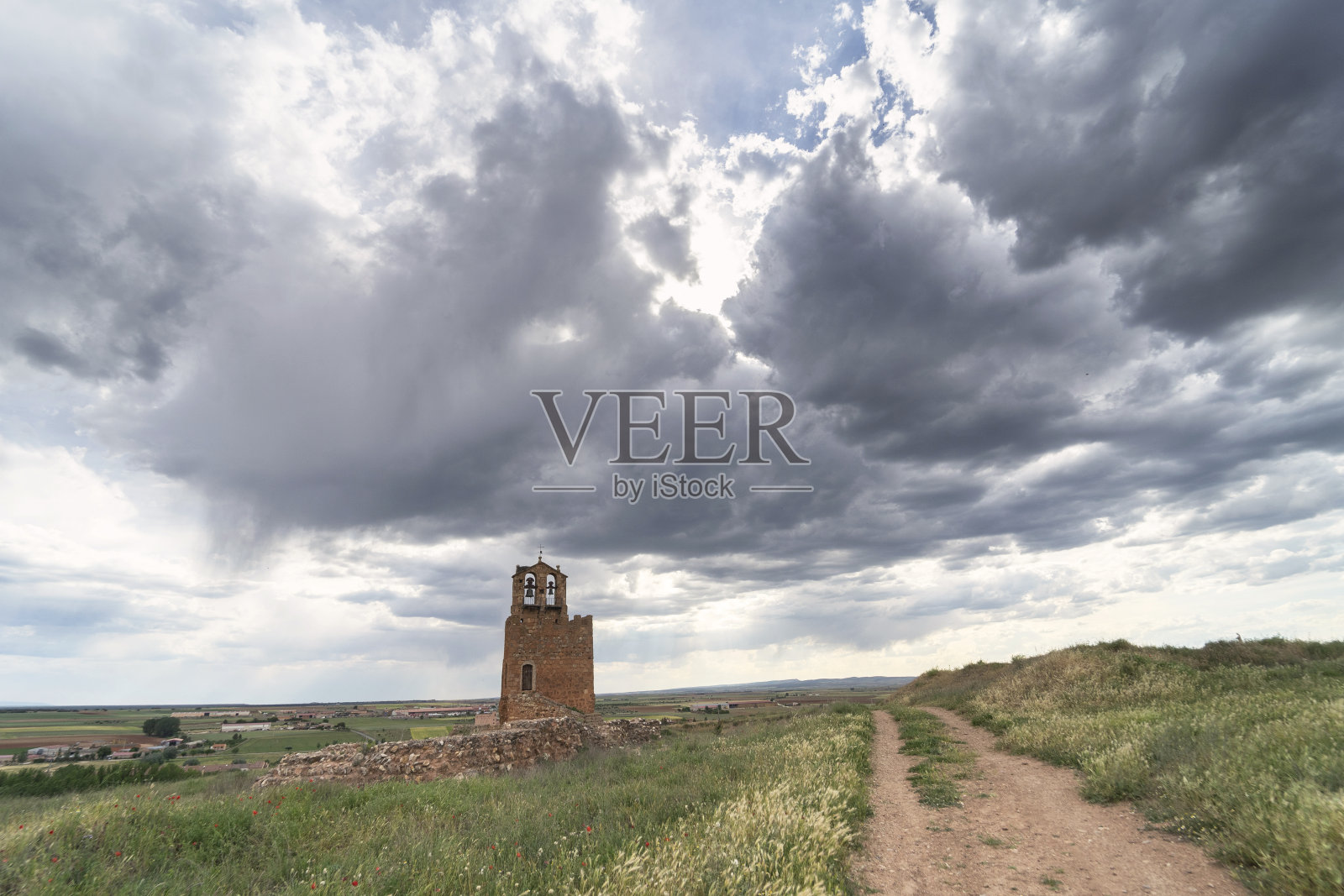 这条小路穿过一片草地和鲜花，通向位于艾永中世纪小镇的玛蒂娜塔照片摄影图片