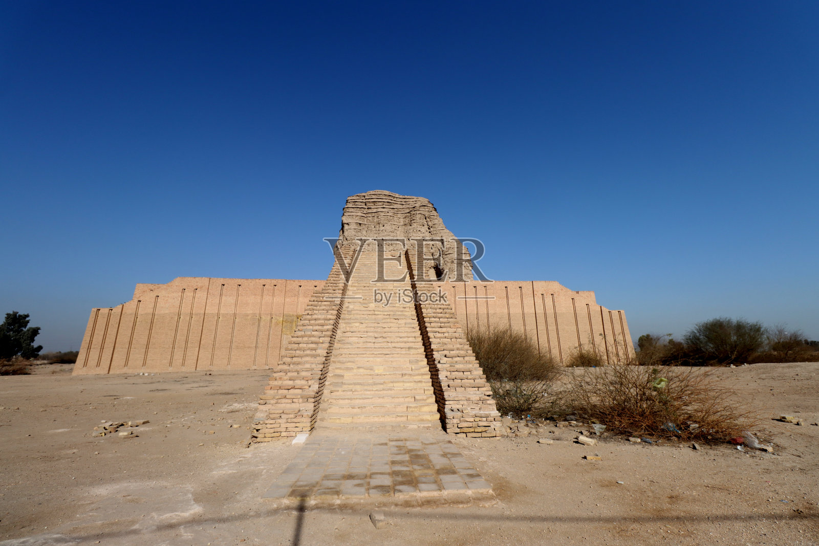 巴格达晴朗的蓝天下，阿卡库夫的金字神像和一块巨石。照片摄影图片