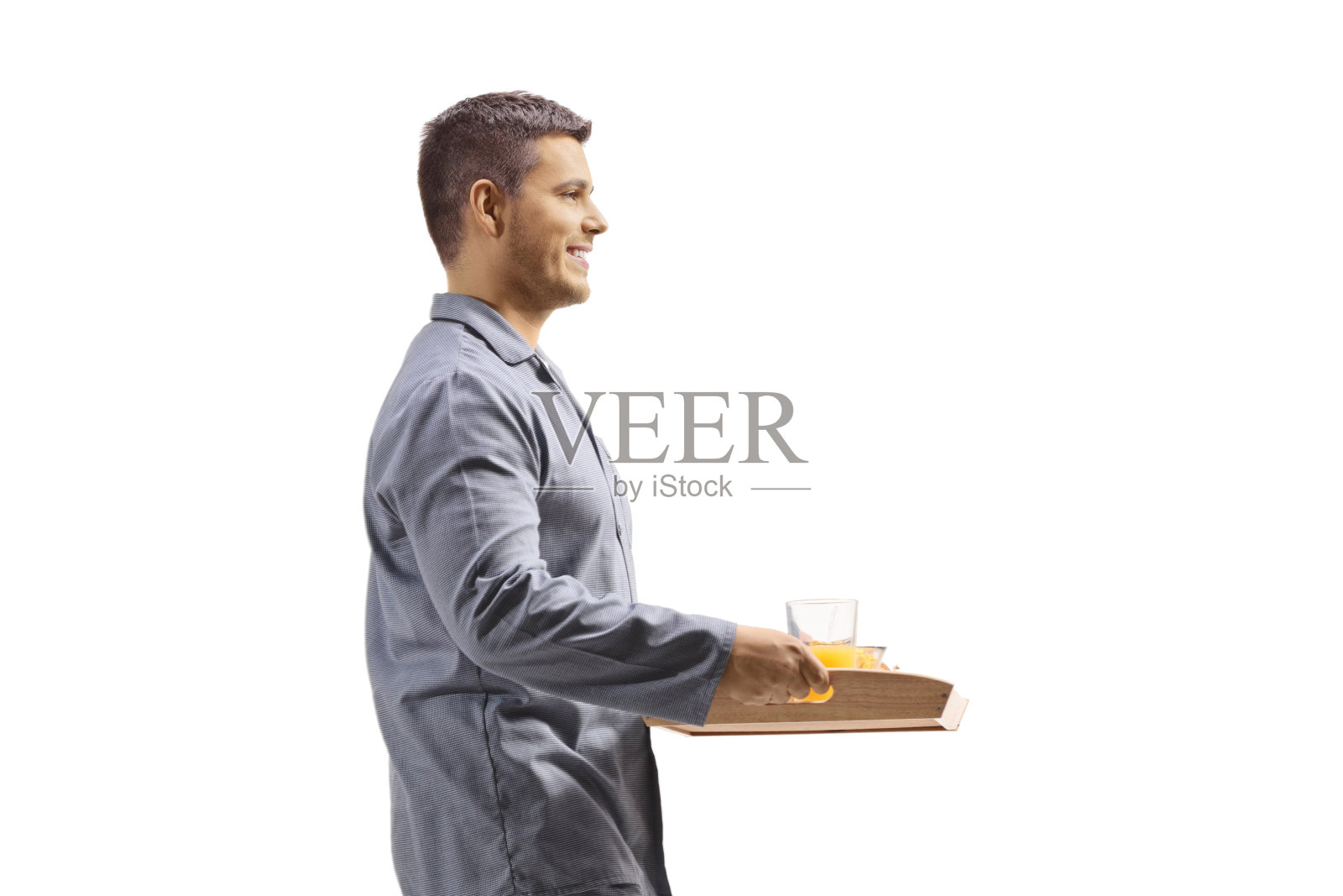 一个穿着睡衣，端着早餐托盘走路的男人照片摄影图片