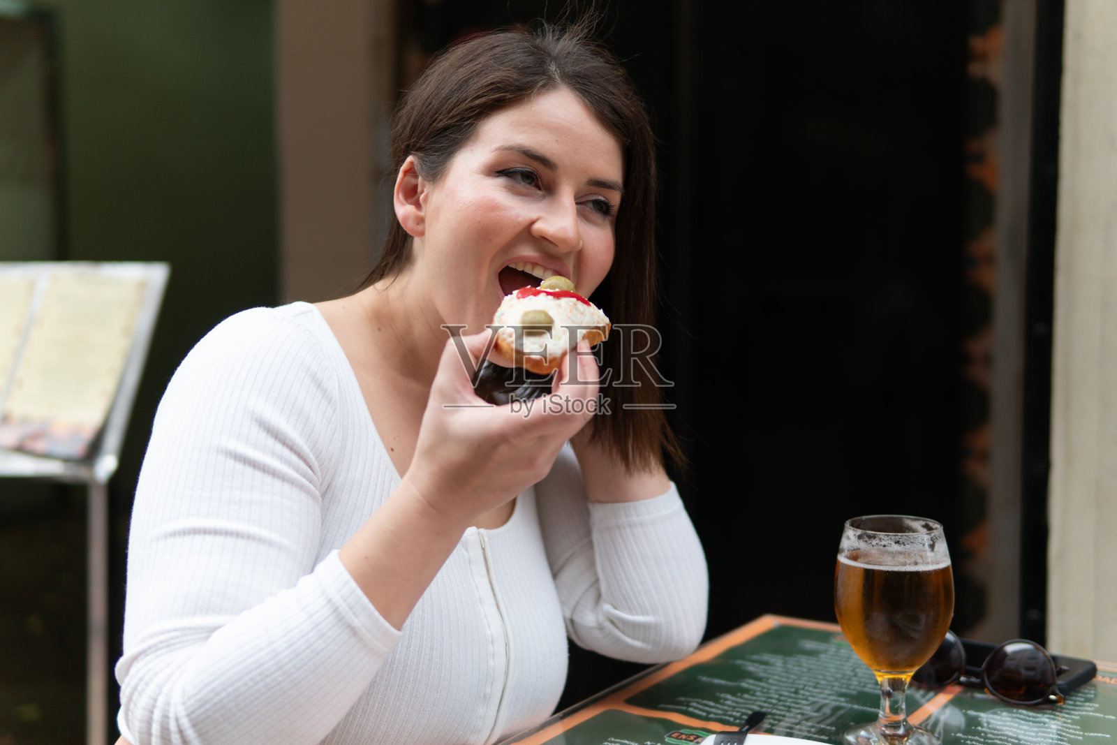 在户外咖啡馆享用小吃和啤酒的女人照片摄影图片