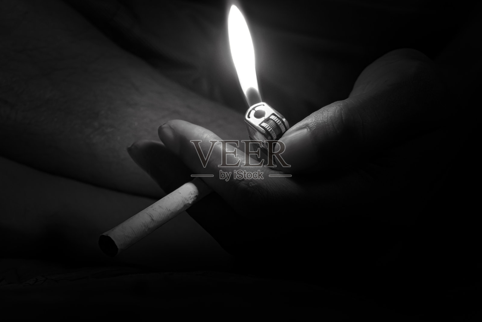 手里拿着香烟和点燃的打火机照片摄影图片