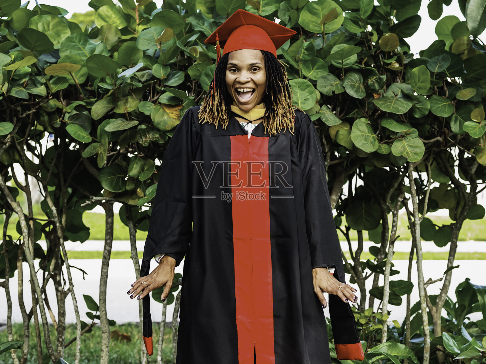 快乐、充满活力、多才多艺的非裔美国女性，30多岁，穿着特别的毕业礼服，她将获得硕士学位照片摄影图片