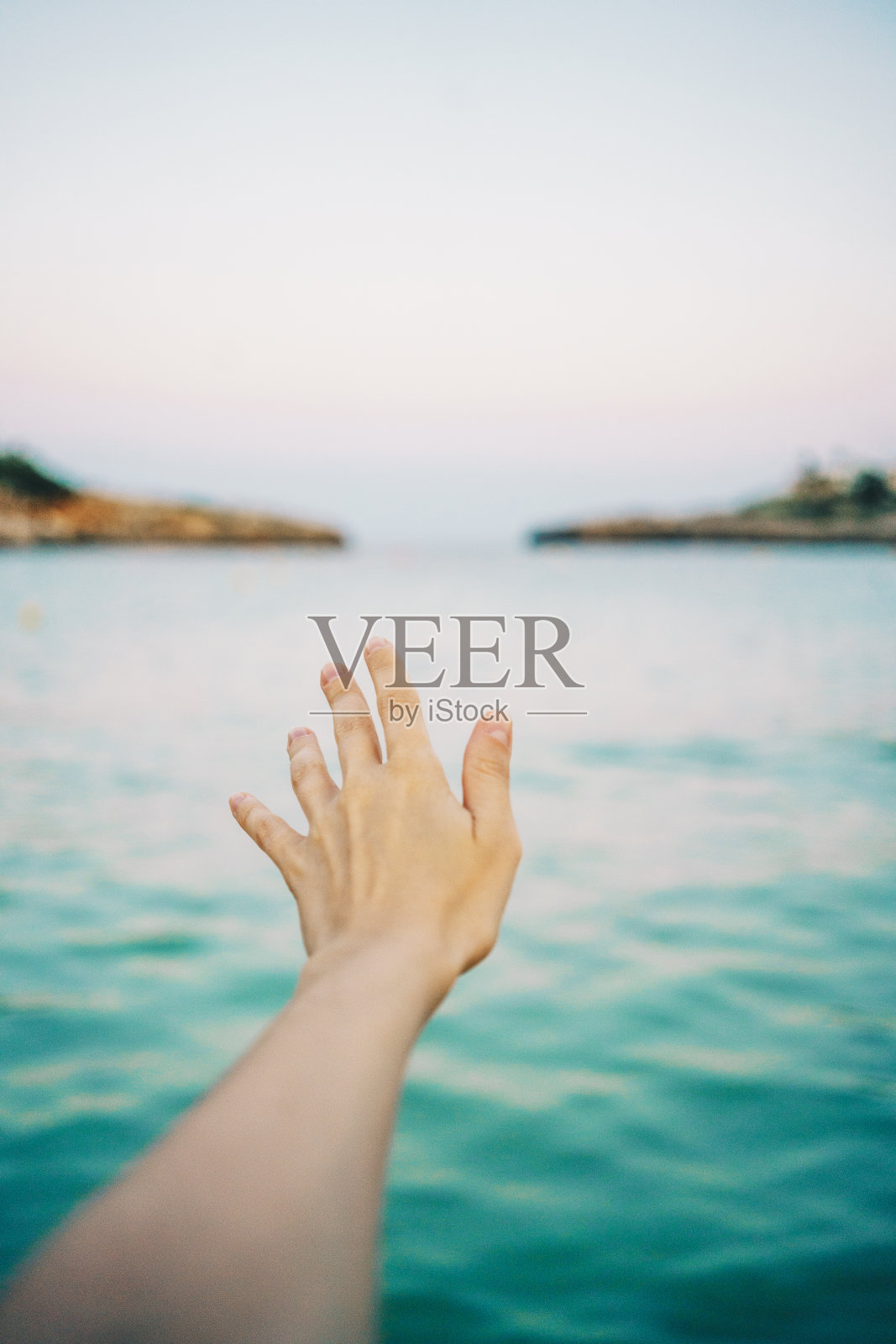 女人的手伸向海上的地平线照片摄影图片