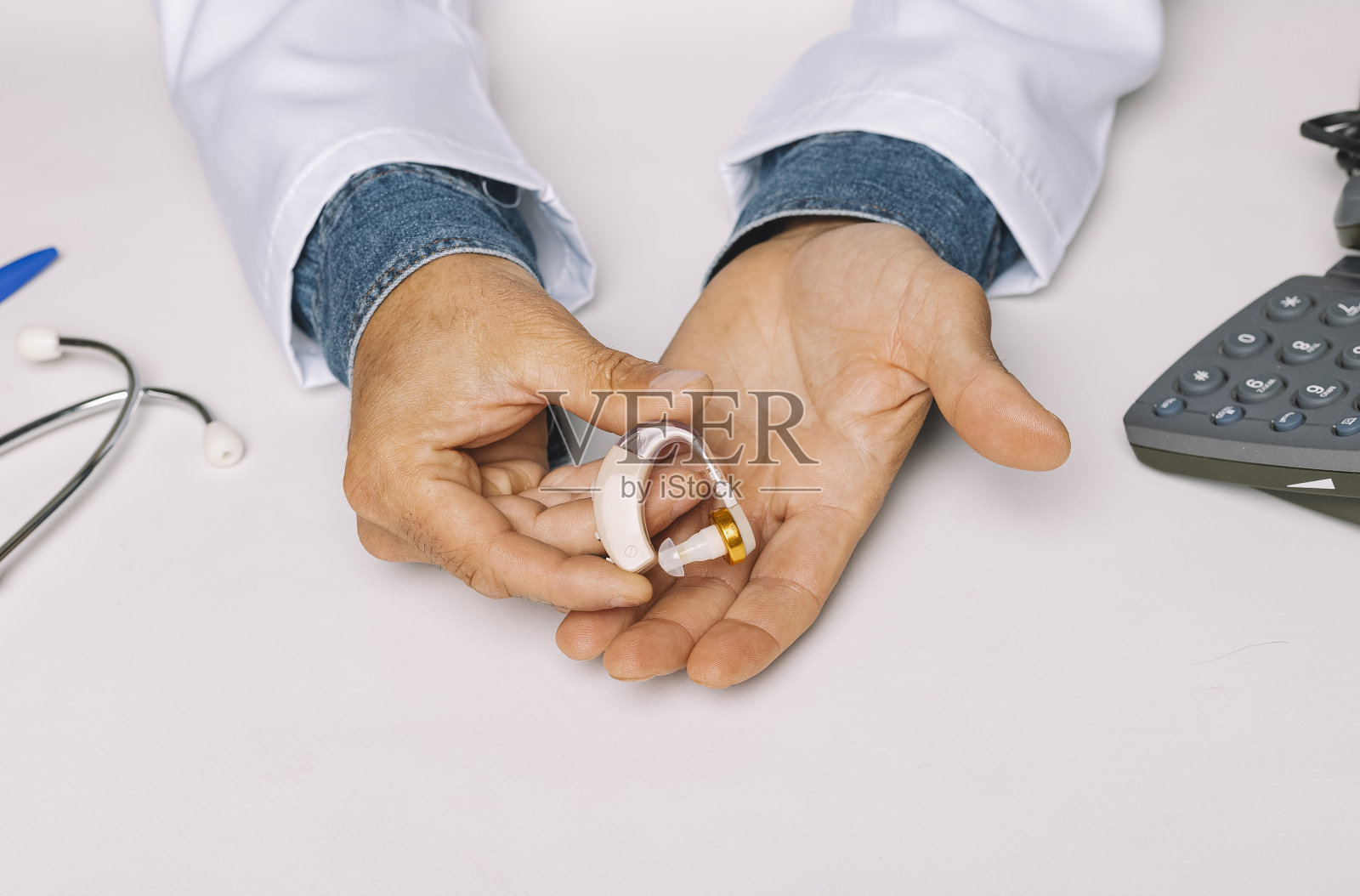 在医院的诊所里，听力学家的手展示着助听器。听力学概念。照片摄影图片