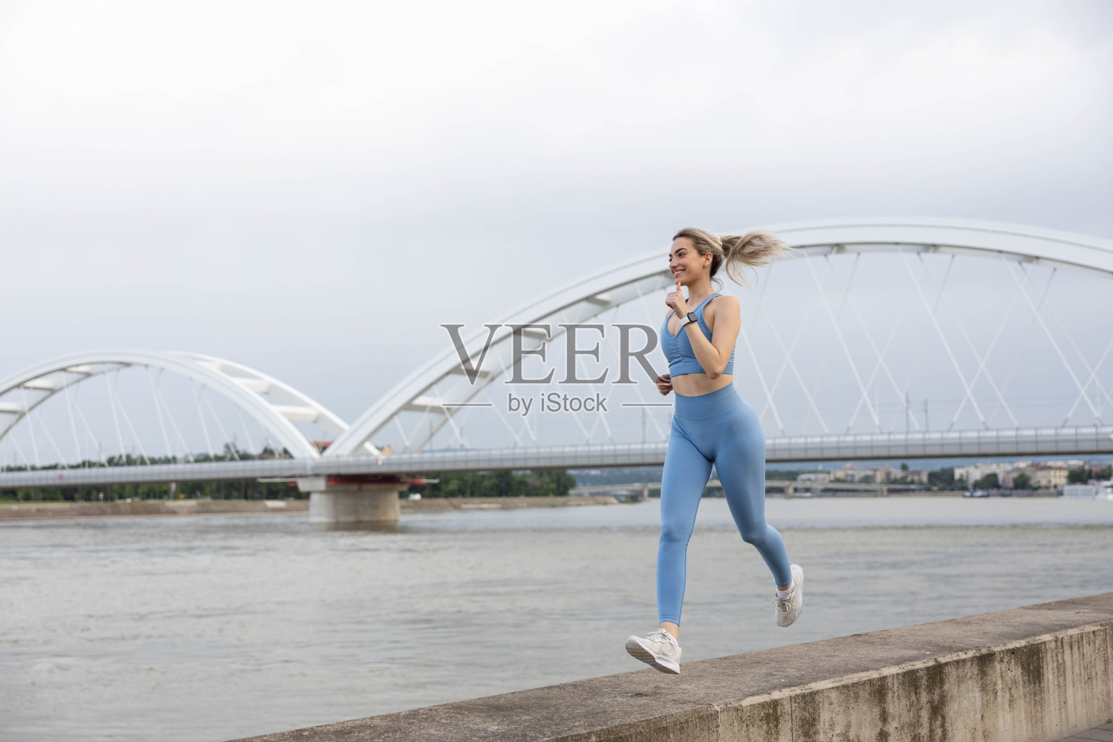 穿着运动服的妇女在码头上跑步照片摄影图片