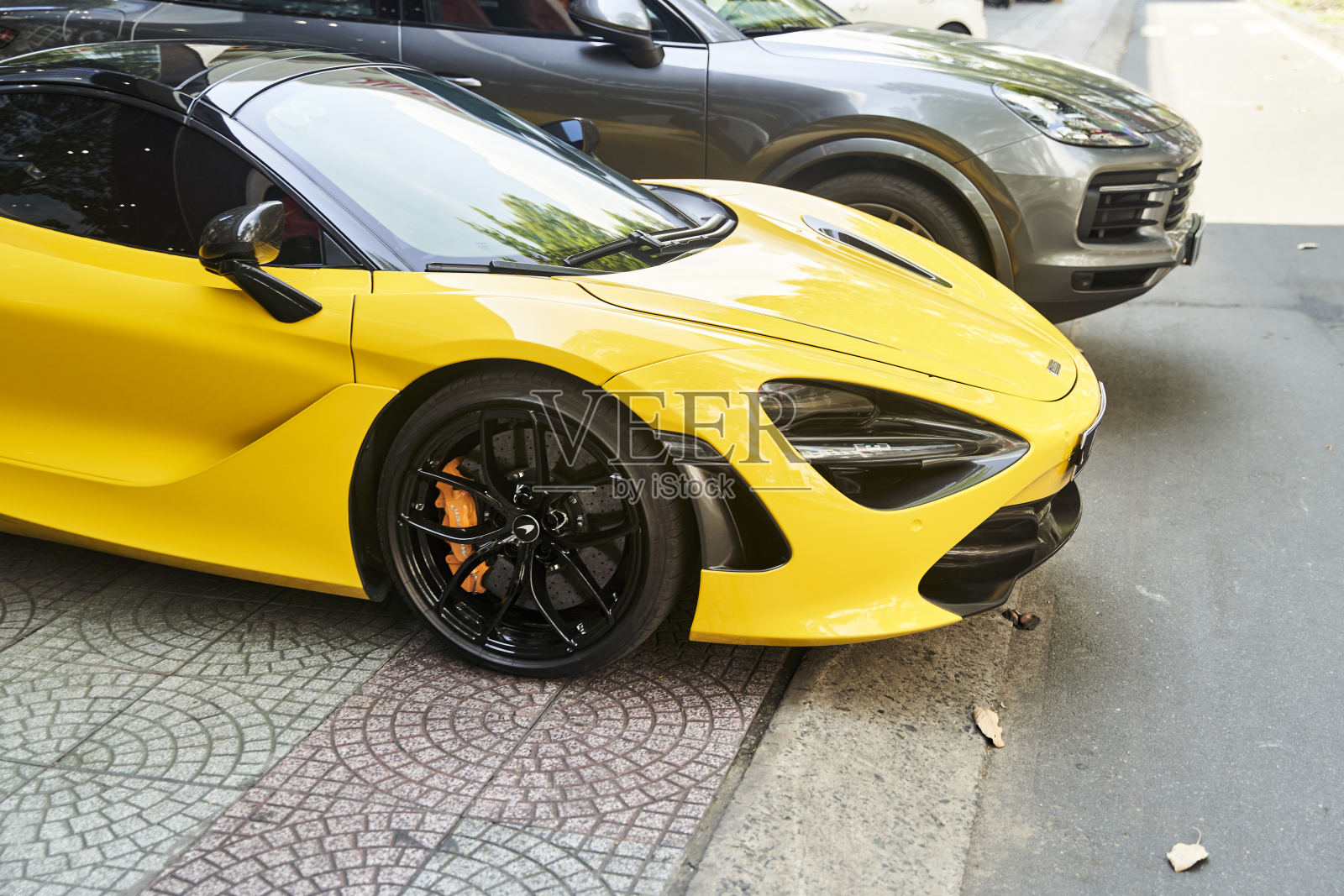 越南胡志明市——2023年7月5日:一辆黄色跑车停在一辆黑色跑车旁边照片摄影图片