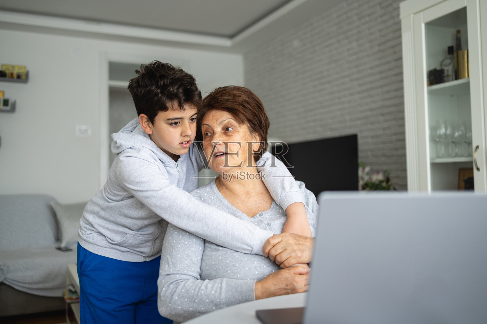 孙子抱着奶奶，用笔记本电脑上网看内容照片摄影图片