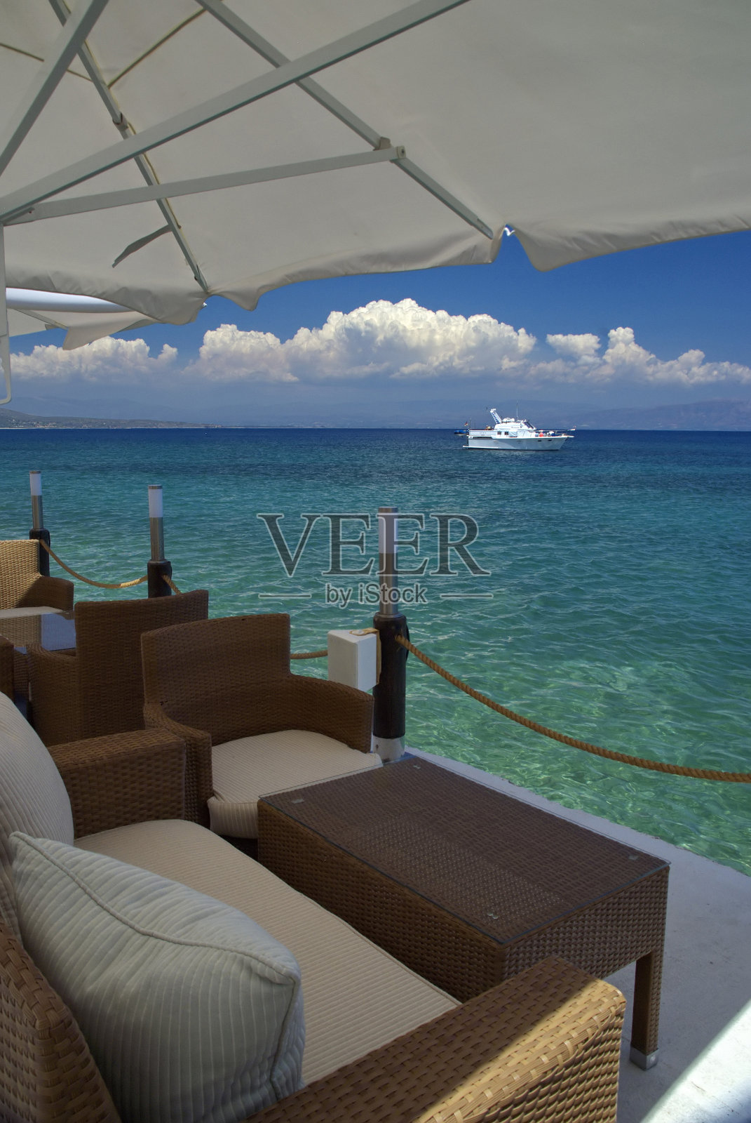 椅子和桌子对着大海和天空的云朵照片摄影图片