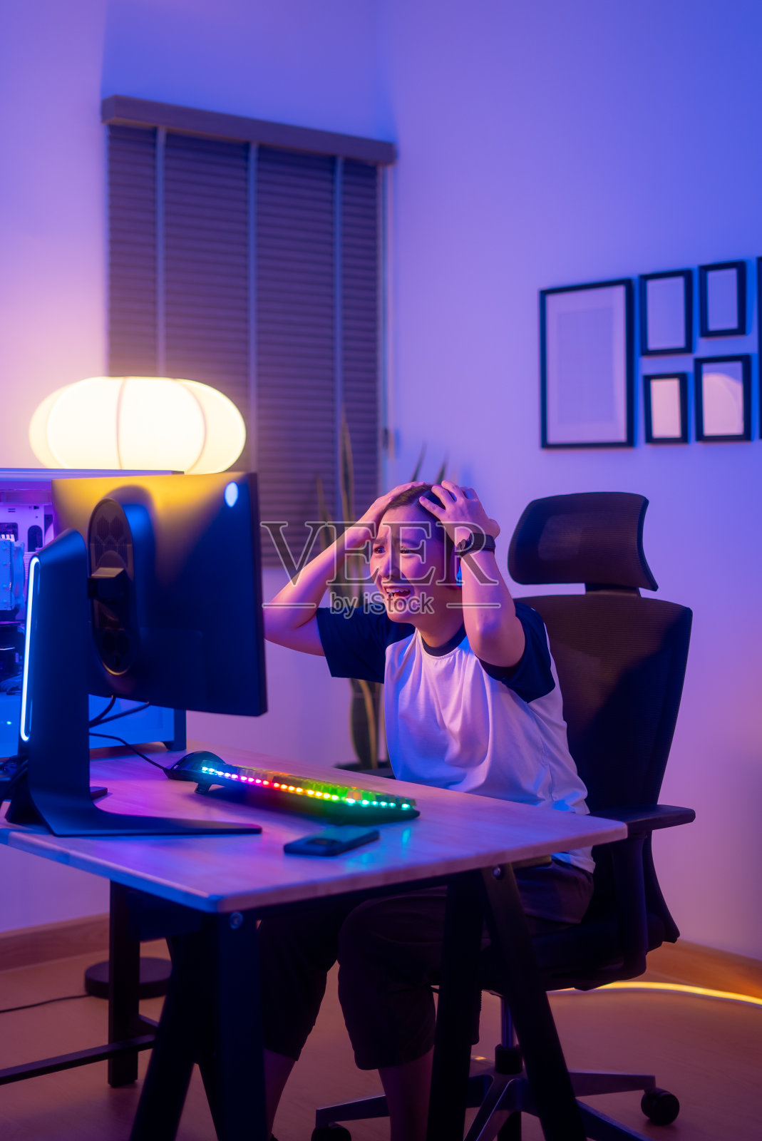 亚洲女玩家戴着耳机玩电脑游戏，在家里输了游戏后感到沮丧。照片摄影图片