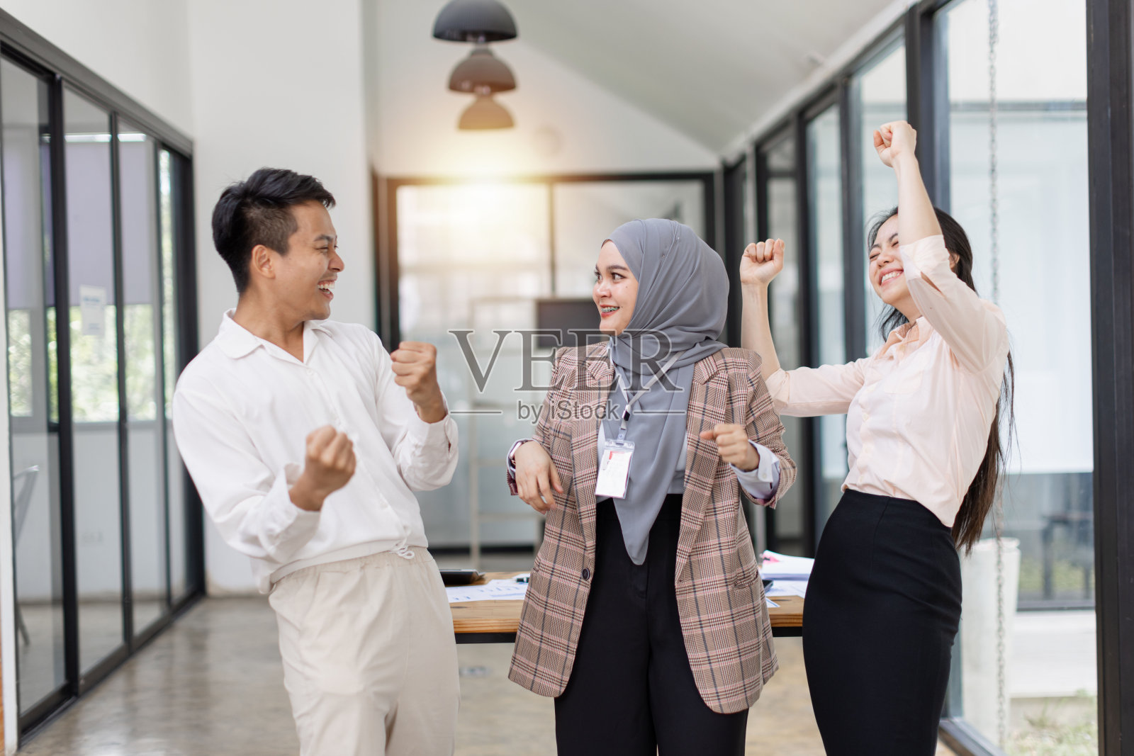 兴奋的亚洲商业团队在办公室庆祝成功。照片摄影图片