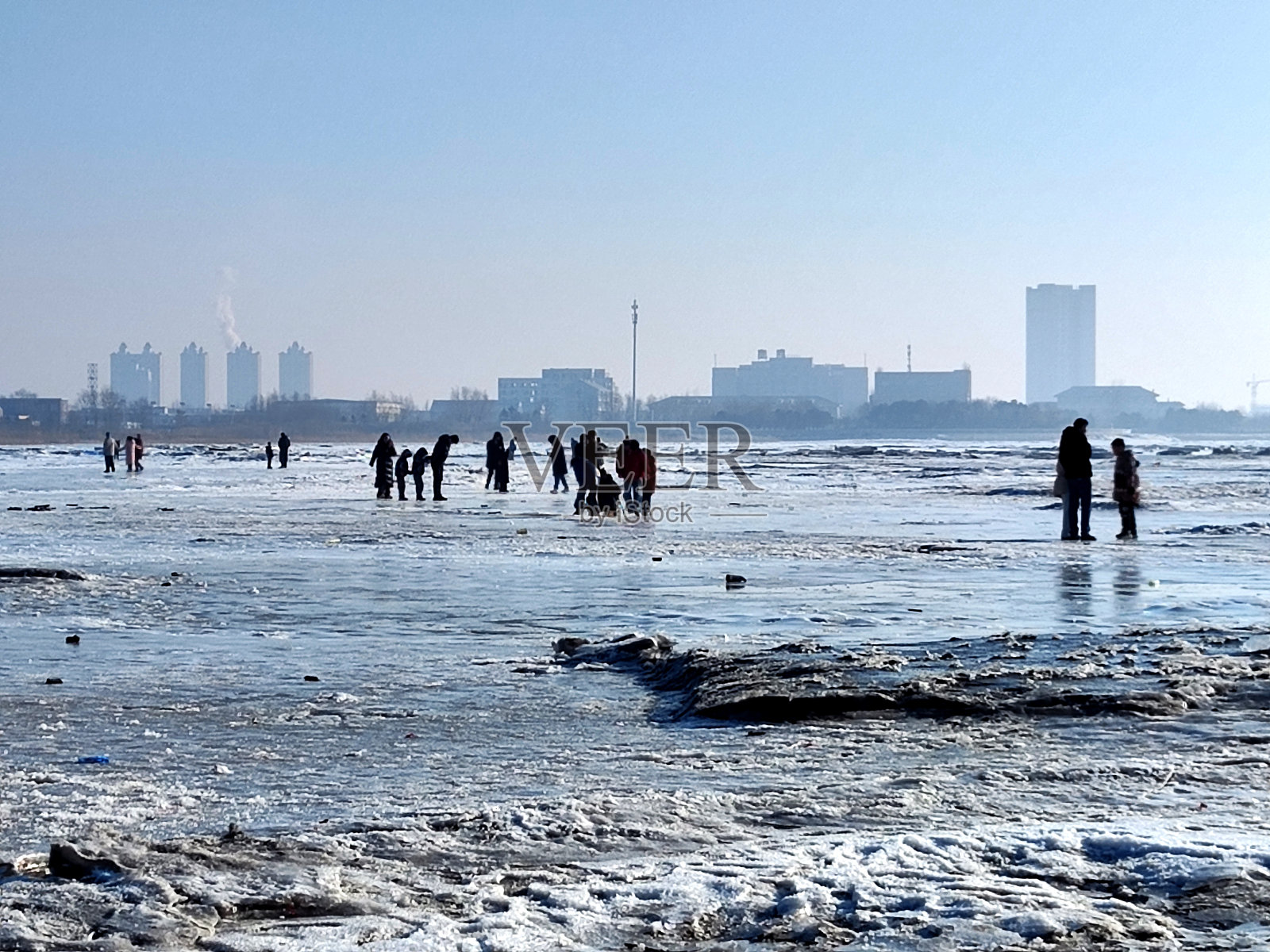 中国辽宁营口，人们走在冰冻的渤海上照片摄影图片