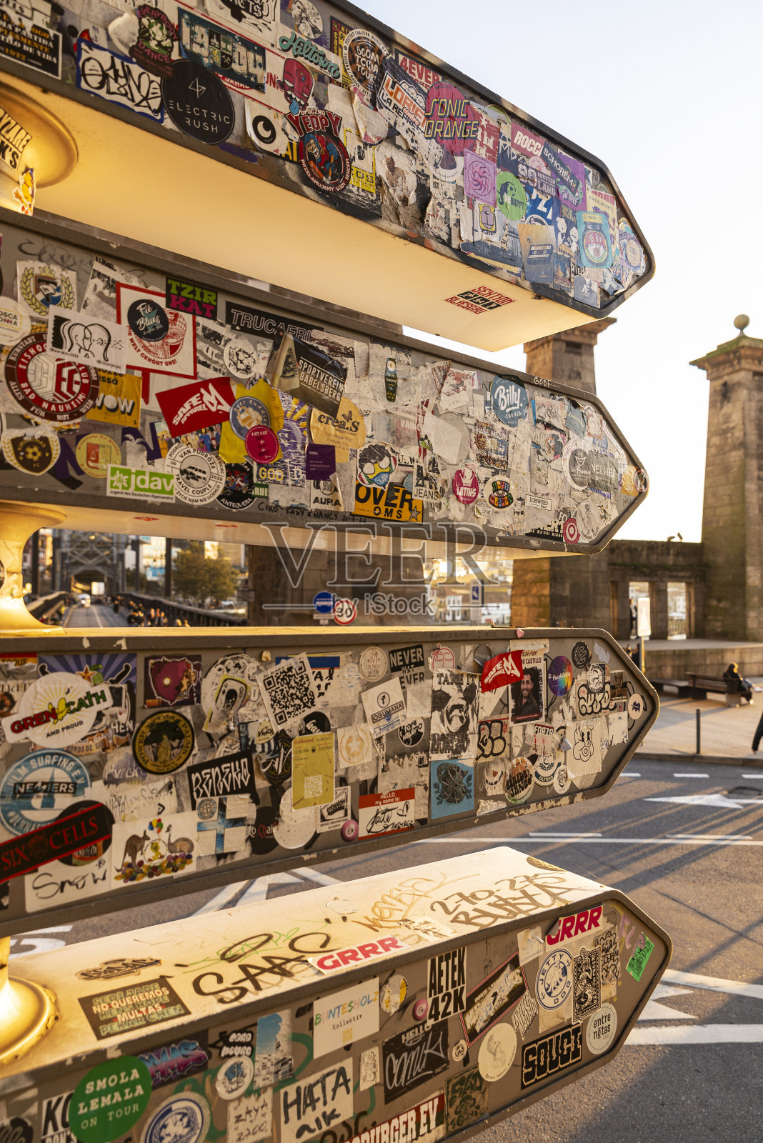 葡萄牙波尔图，箭头交通指示牌上的广告贴纸拼贴照片摄影图片