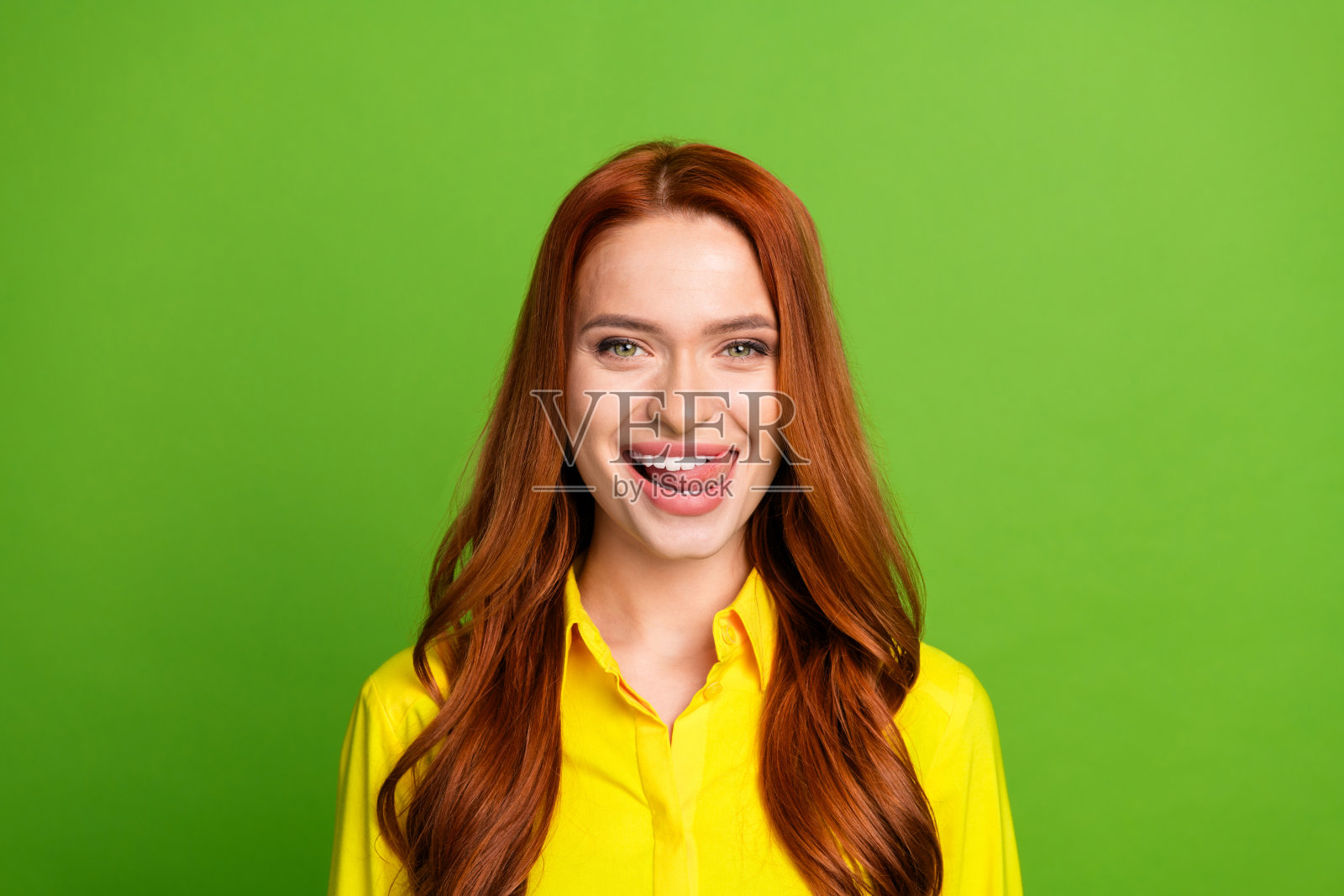 漂亮的年轻女孩的照片肖像舔牙美味穿着时髦的黄色服装孤立的绿色背景照片摄影图片