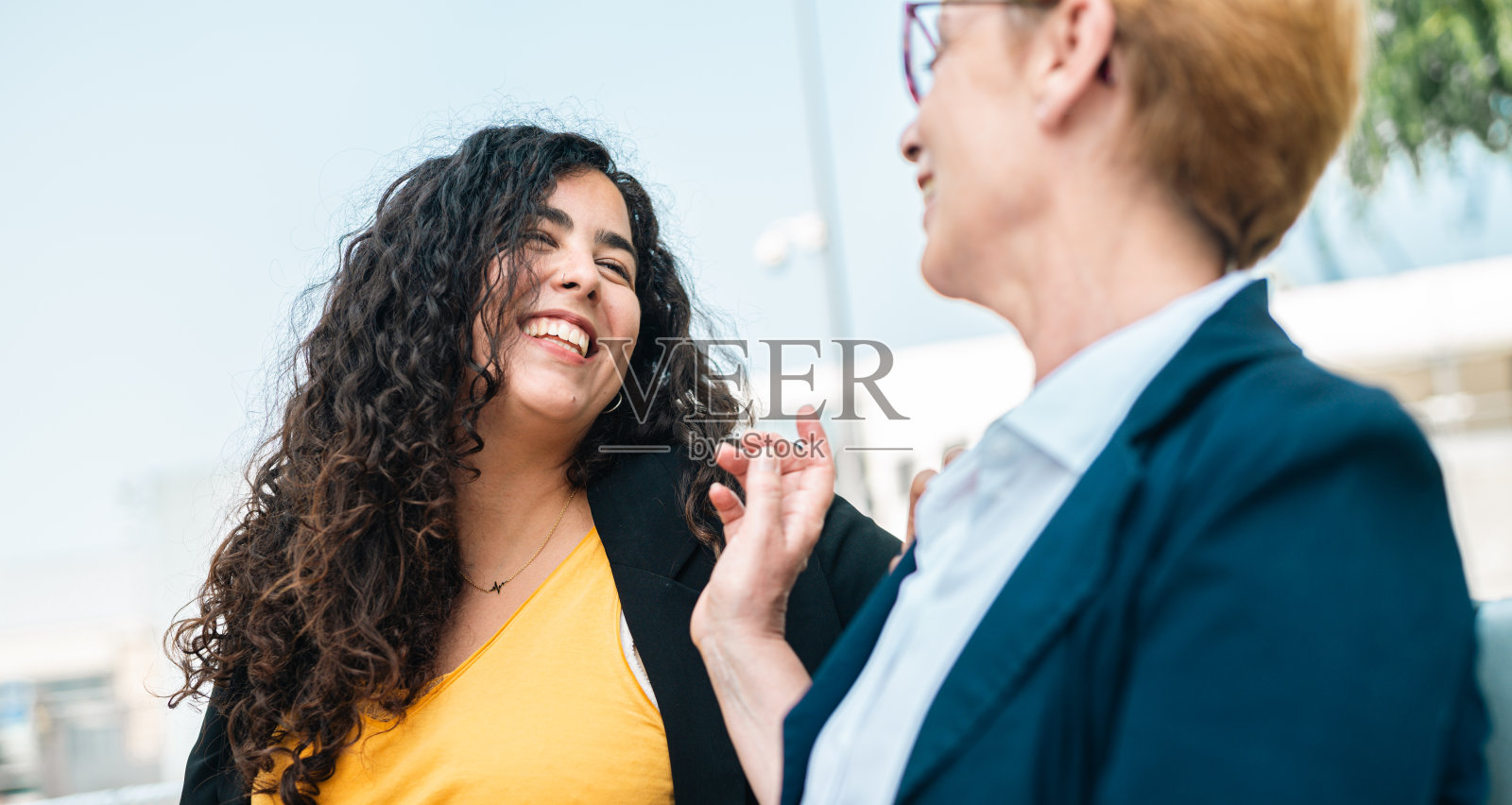 上班族坐在人行道的长椅上，放松时间，学习老年人的办公理念照片摄影图片