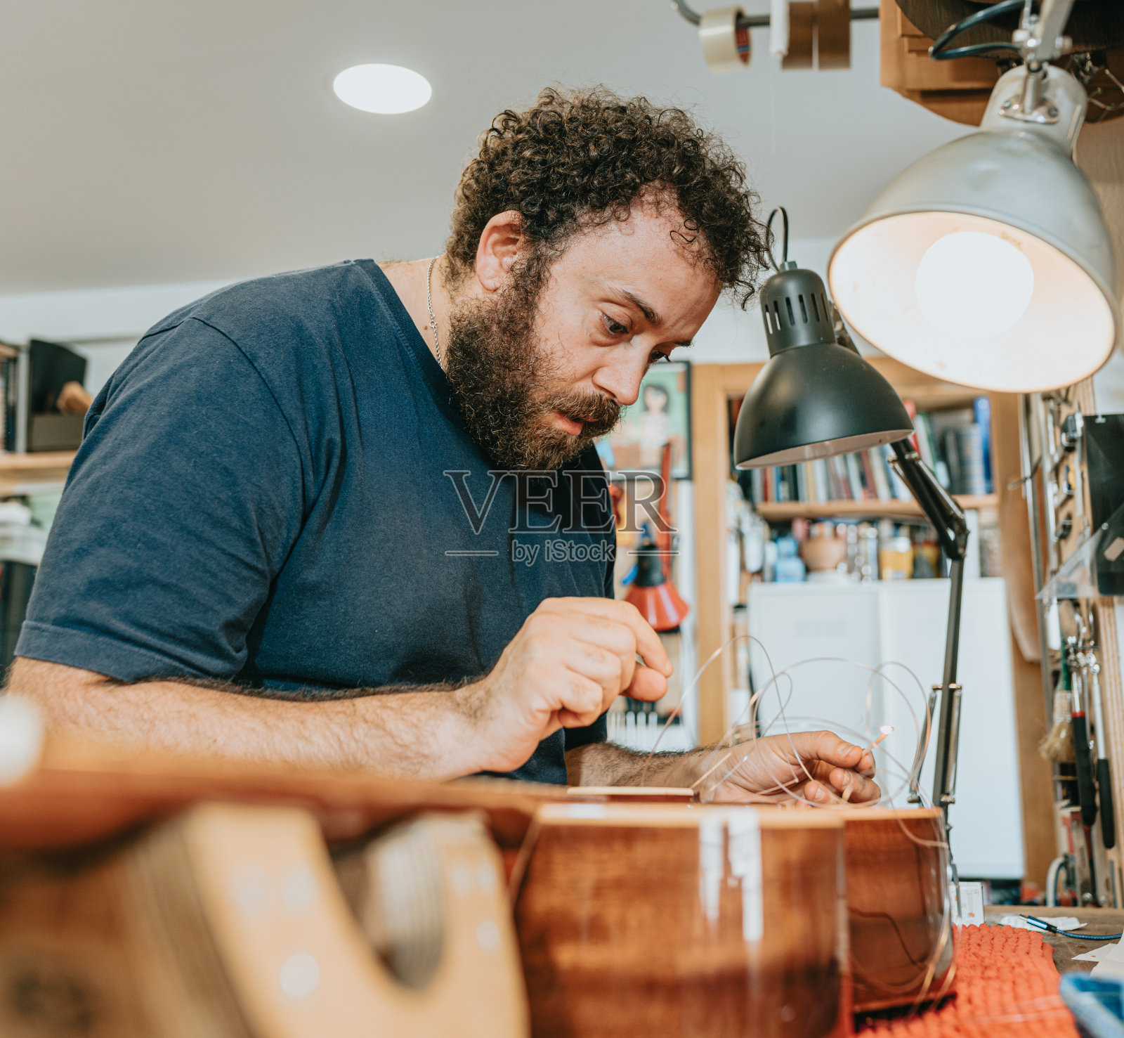 工匠在工作室制作吉他照片摄影图片