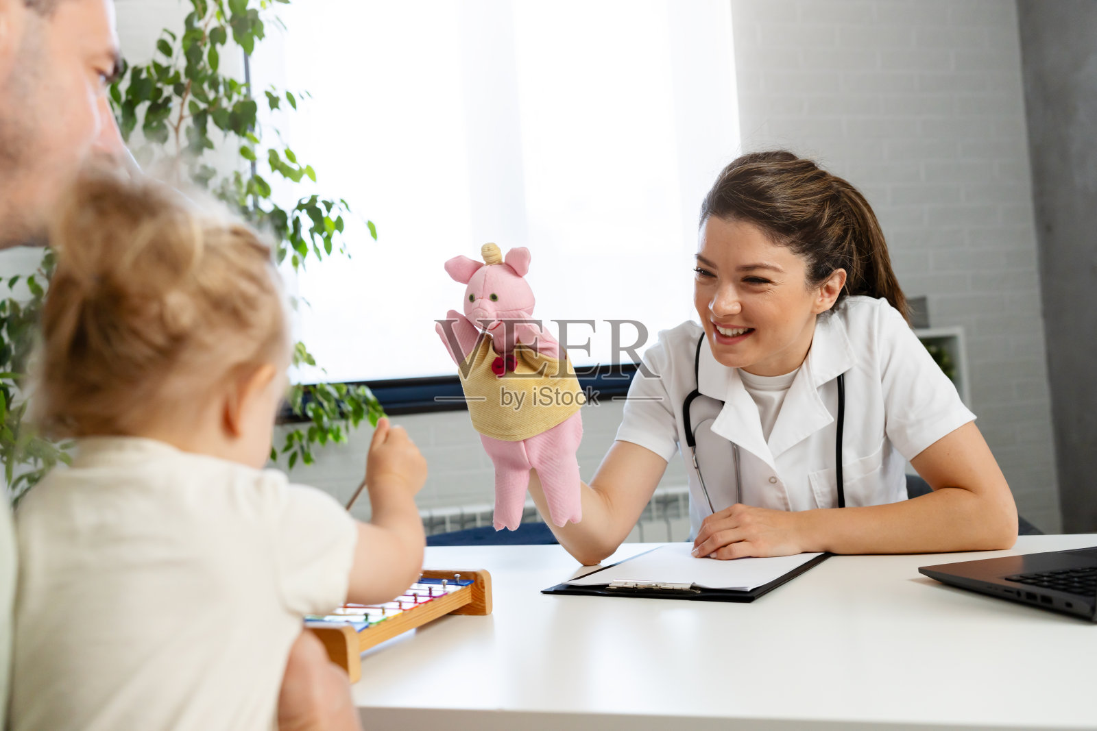 一位女儿科医生正在检查她的小女孩病人照片摄影图片
