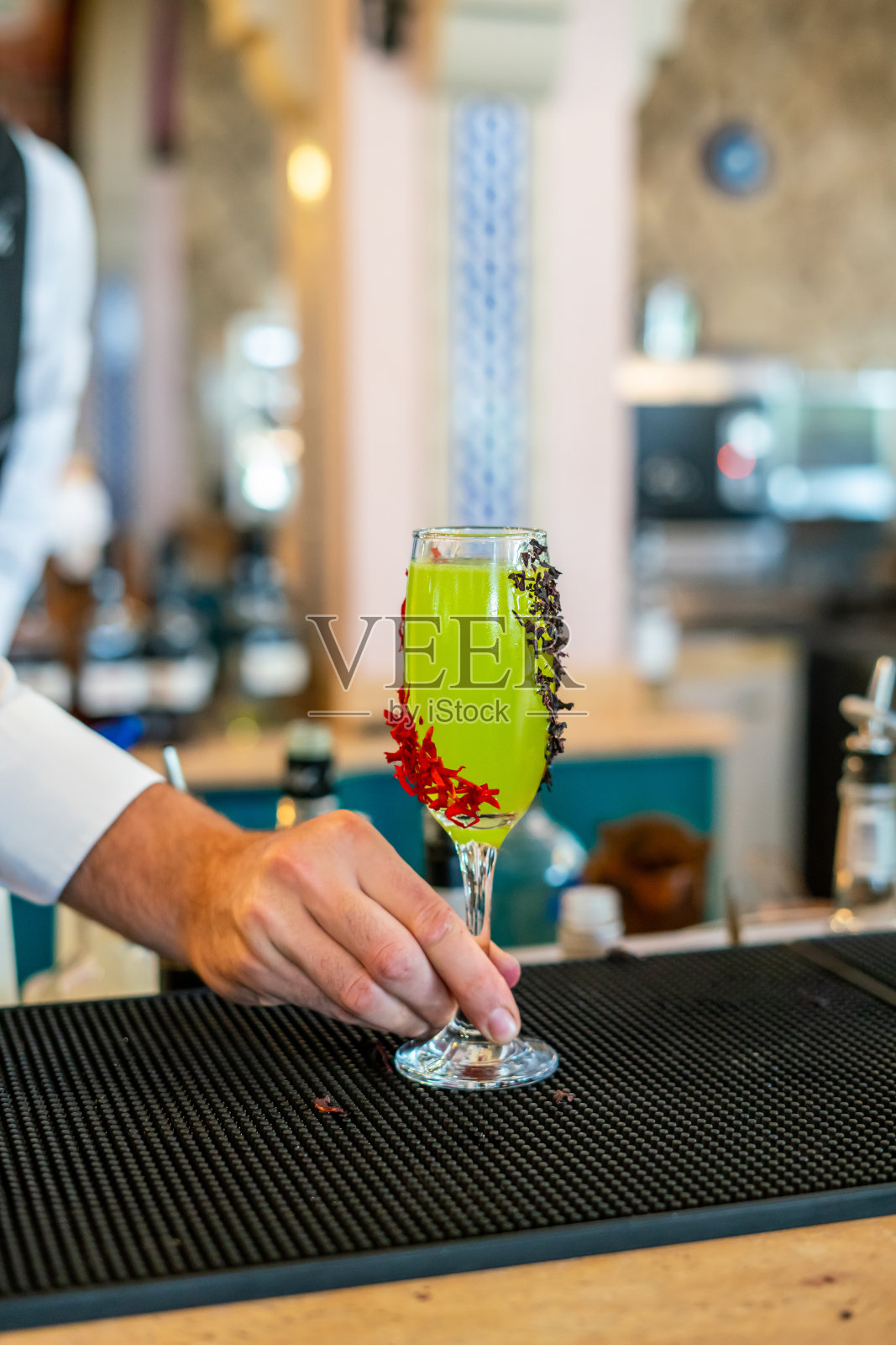 黄色鸡尾酒在吧台上，调酒师正在提供垂直的食品和饮料蒸馏器照片摄影图片