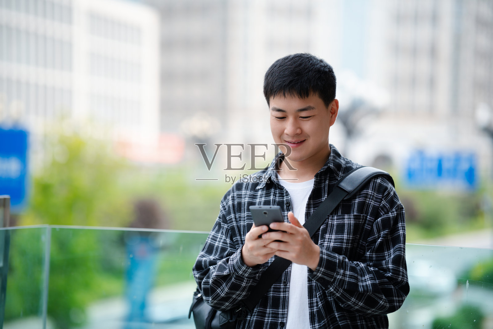 亚洲帅哥在城市街道上使用智能手机照片摄影图片